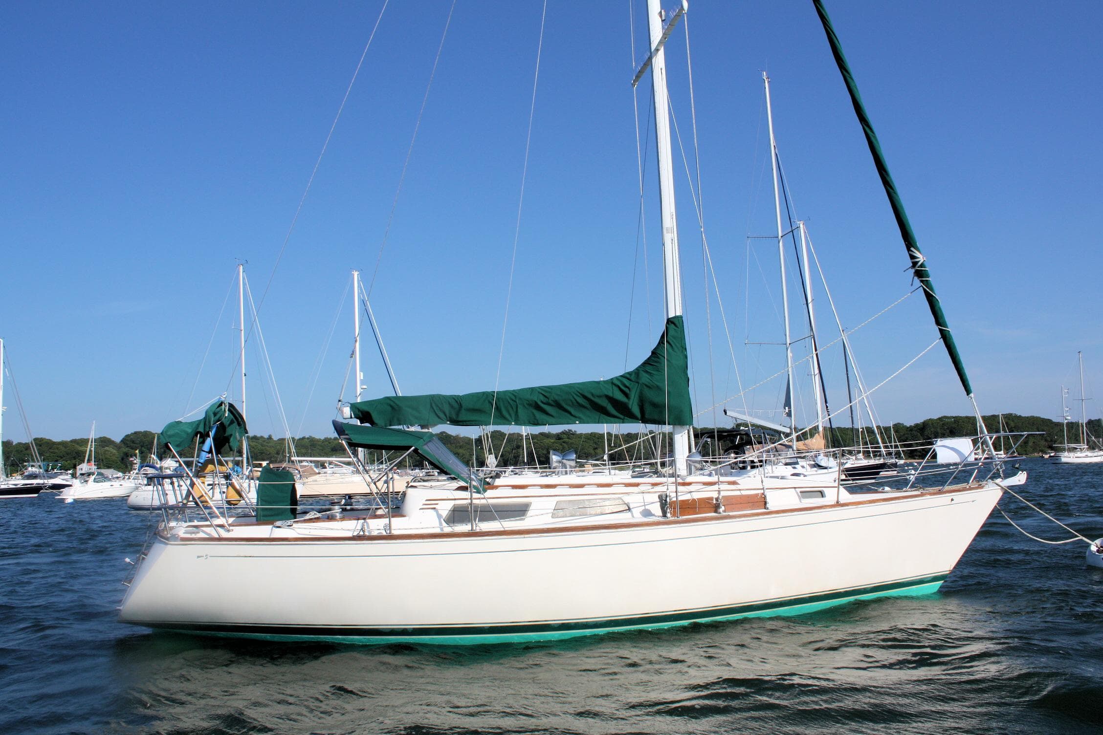 1986 Sabre 34 MK II sailboat with green covers, anchored in a marina.
