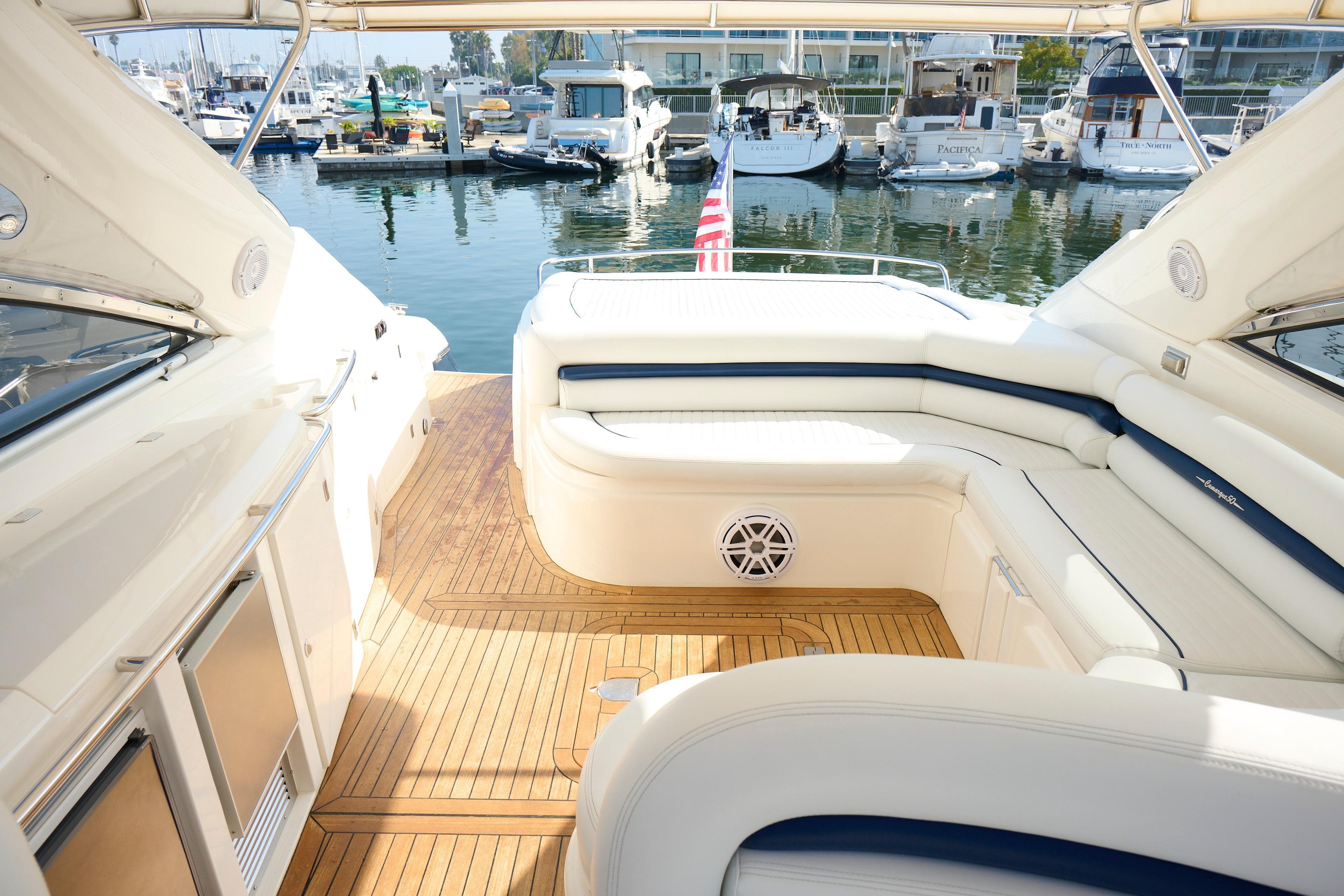 Luxurious Sunseeker Camargue 50 yacht interior with elegant seating, docked at a marina.