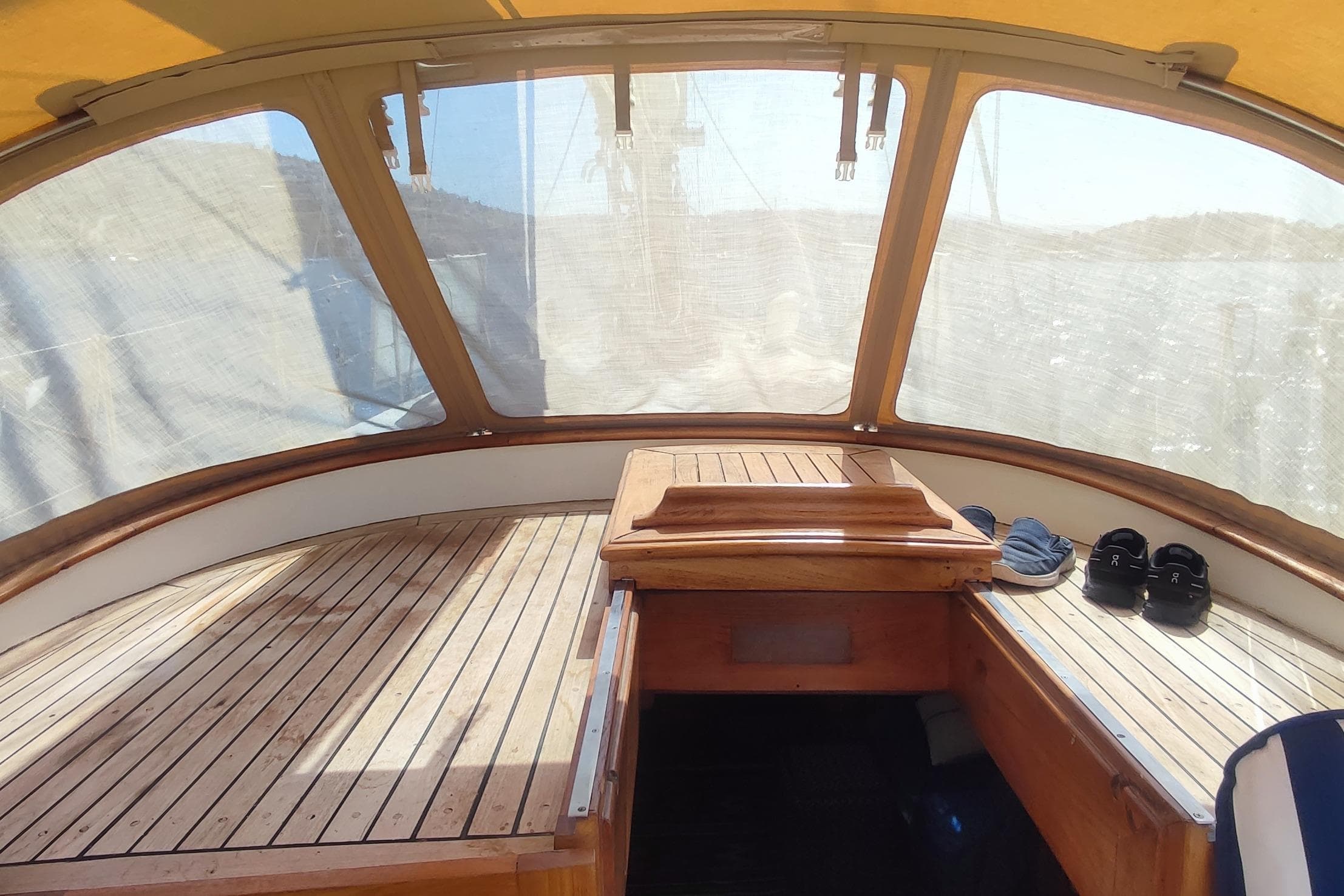1980 Formosa 51 yacht cockpit with wooden deck and shoes, under a canopy.