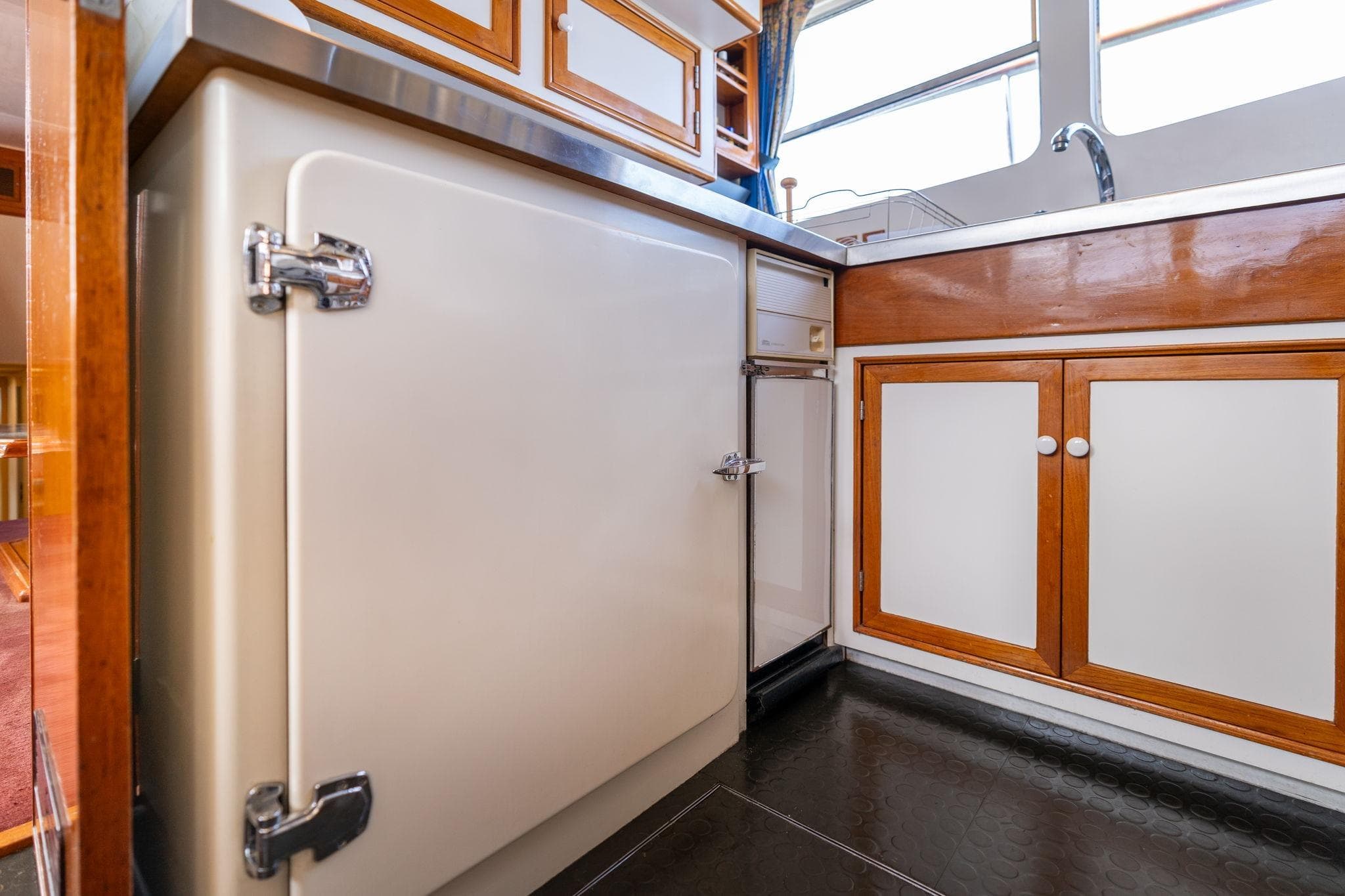 Vintage kitchen interior of 1965 De Vries Lentsch 64 Motoryacht with wooden cabinets.