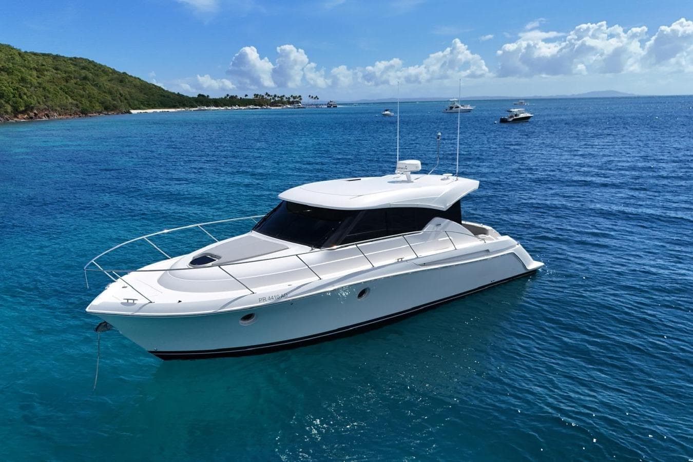 2022 Tiara Yachts C39 Coupe on clear blue water near a lush green island.