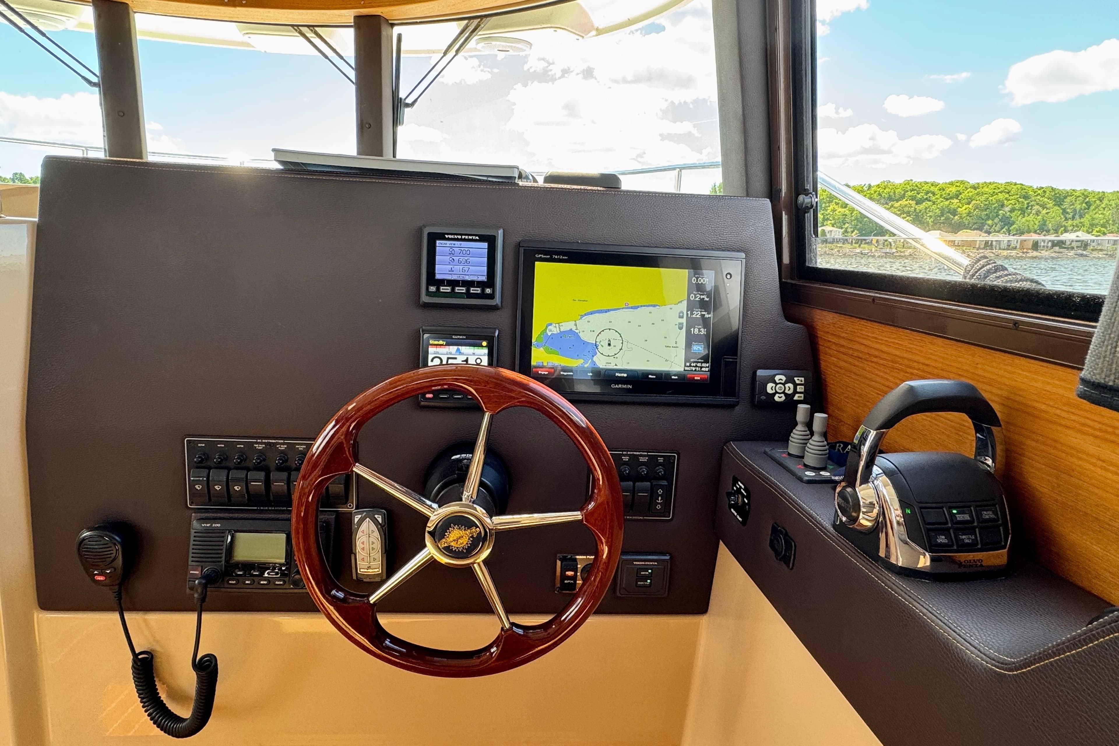2017 Ranger Tugs R-29 CB helm with navigation display and controls, overlooking scenic waterway.