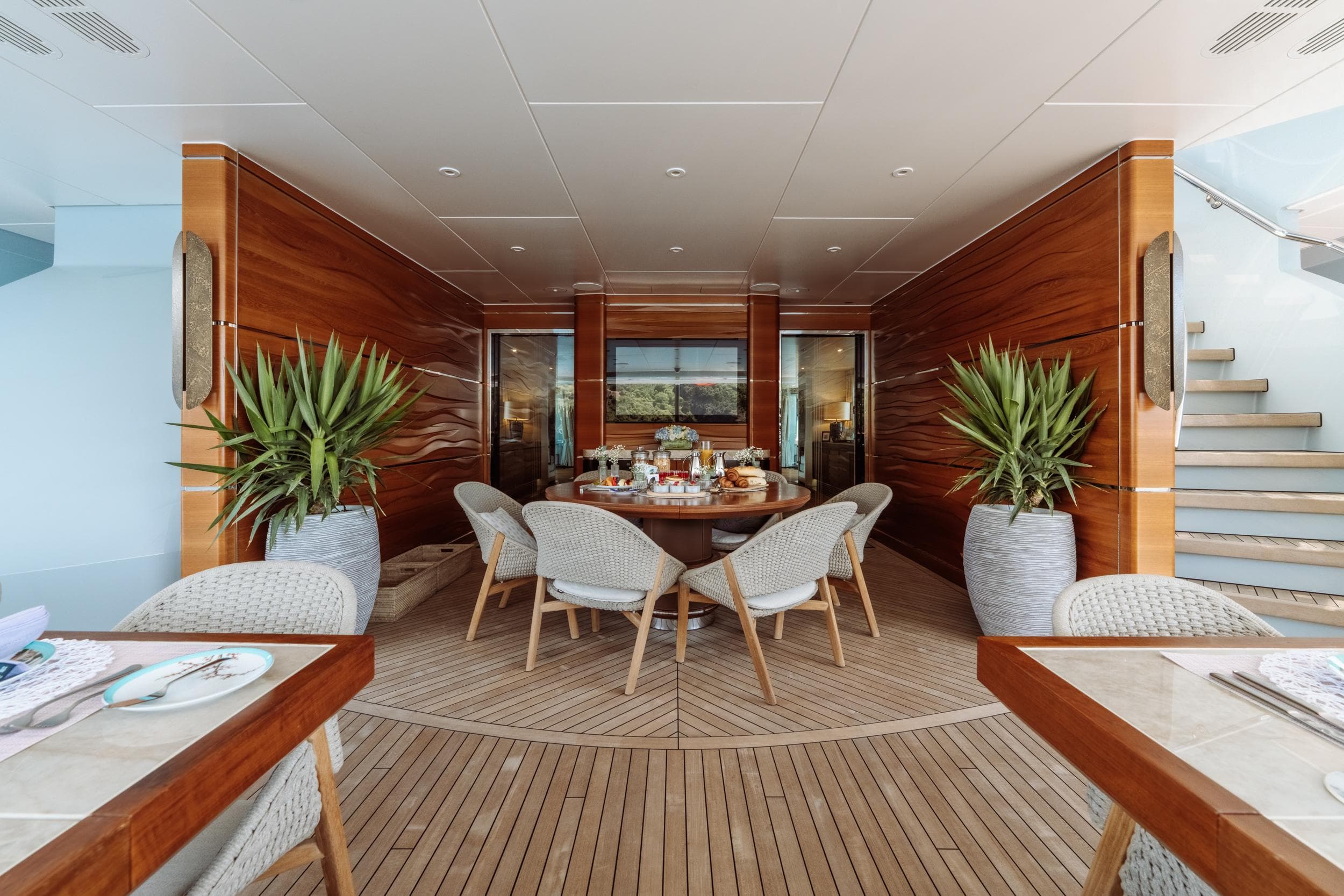 Luxurious dining area on 2011 Heesen 55m yacht with elegant wood paneling and modern decor.