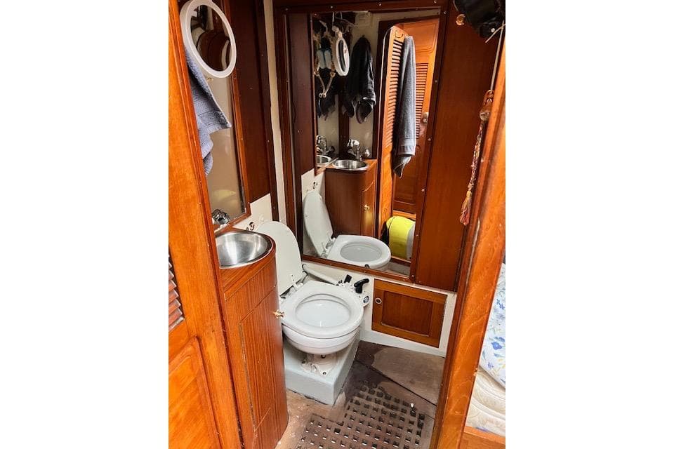 1985 Robert Clark Ketch yacht bathroom with wooden cabinetry and compact fixtures.