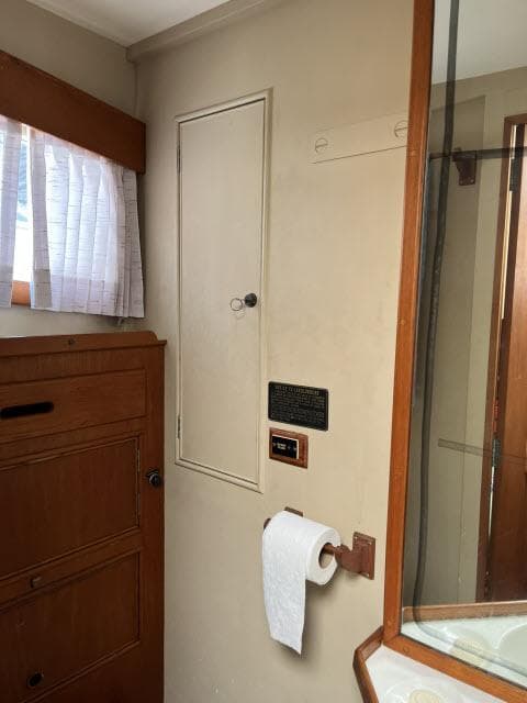 1981 Grand Banks 36 Classic bathroom with wooden cabinetry and a small window.