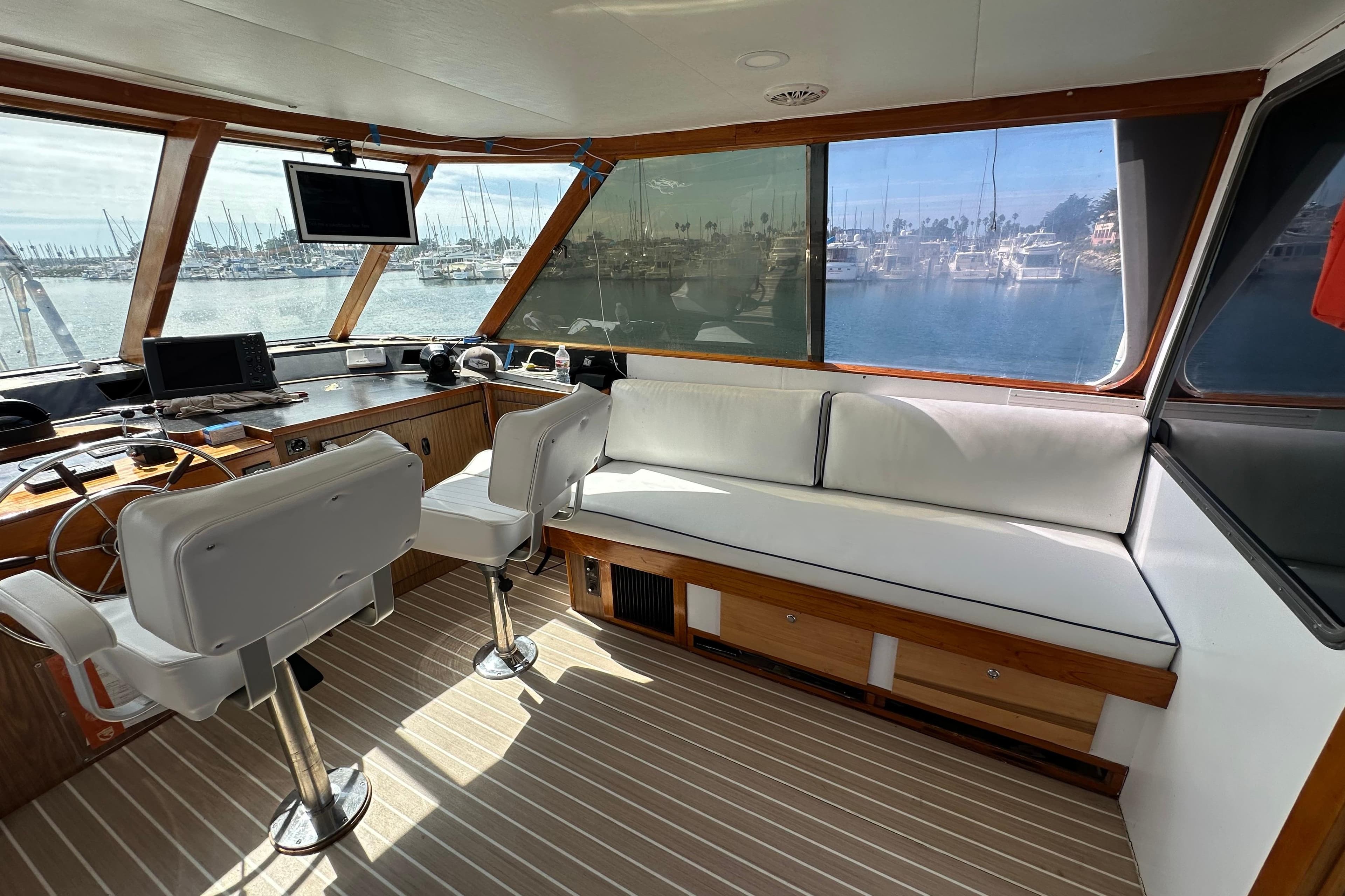 Interior of 1973 Elliott Yachtfisher with helm, seating, and marina view.