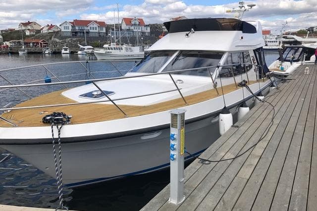 1998 Storebro 430 Royal Cruiser docked at a marina with scenic waterfront views.