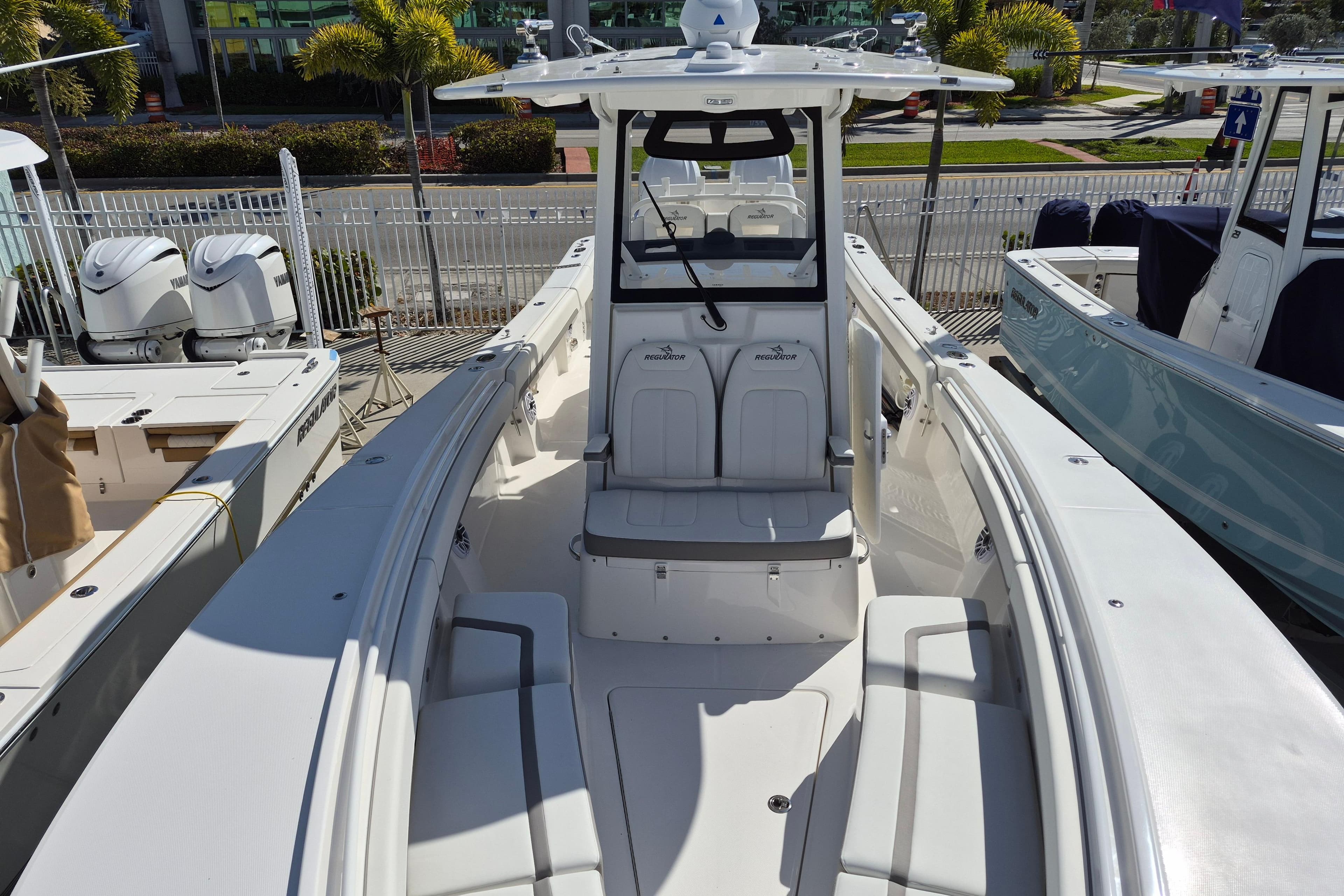 2026 Regulator 31 boat with spacious seating and modern design, docked near palm trees.