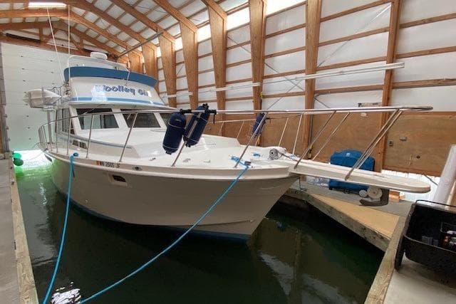 1977 Uniflite 42 Convertible boat docked in a covered marina.