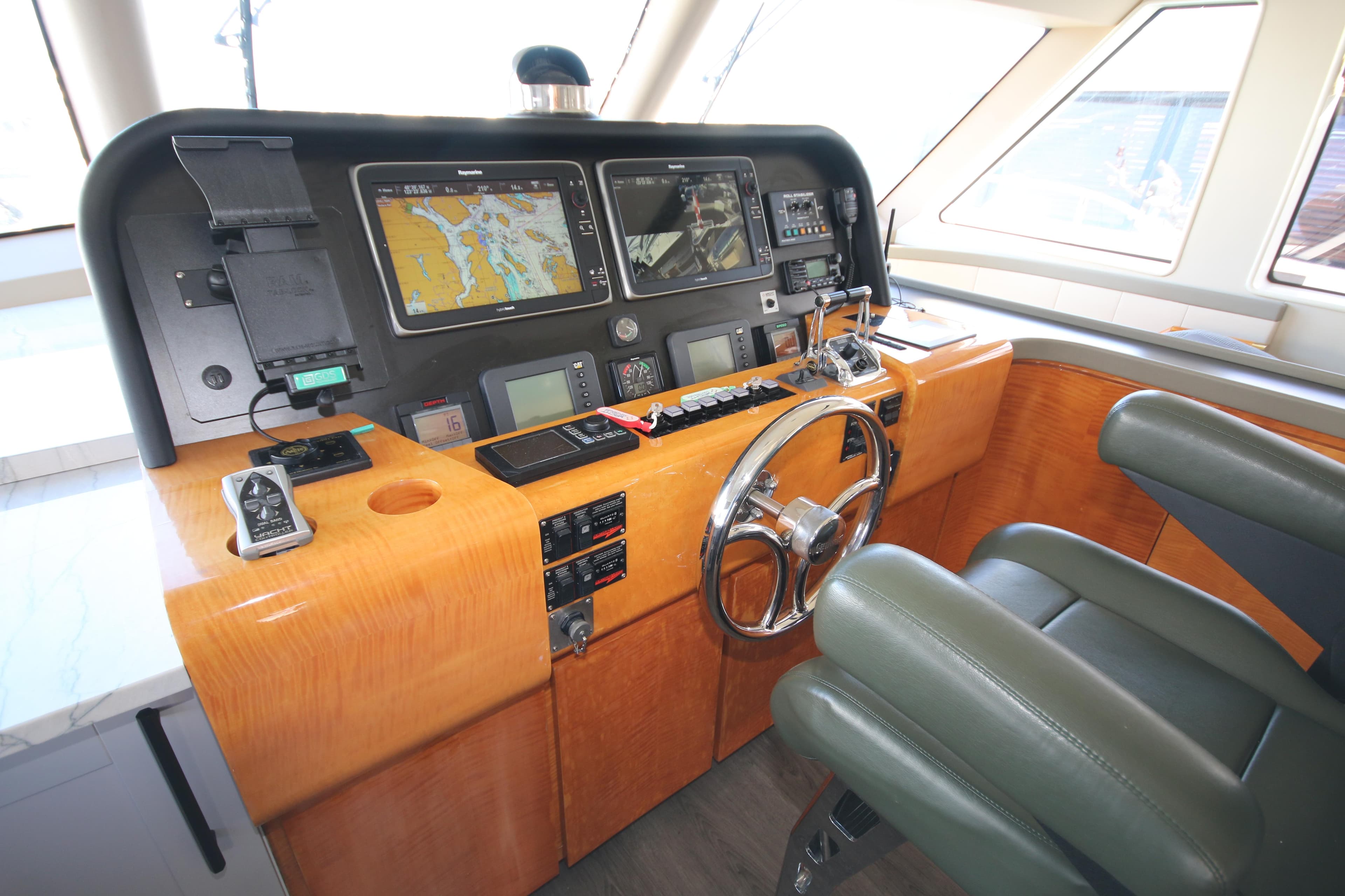 Pilothouse of 2002 Cheoy Lee 66, featuring navigation equipment and leather seating.