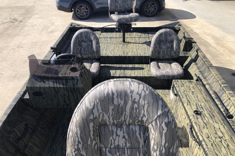 2026 Lund 1870 Predator SC boat with camouflage seating and steering console.