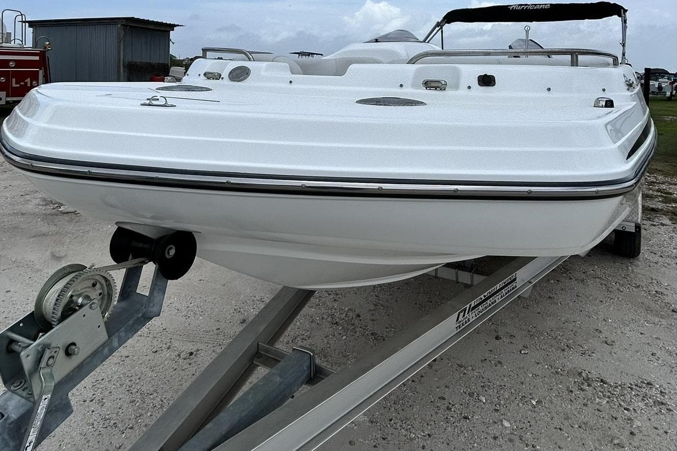 2018 Hurricane SunDeck Sport 232 OB boat on trailer, parked outdoors.