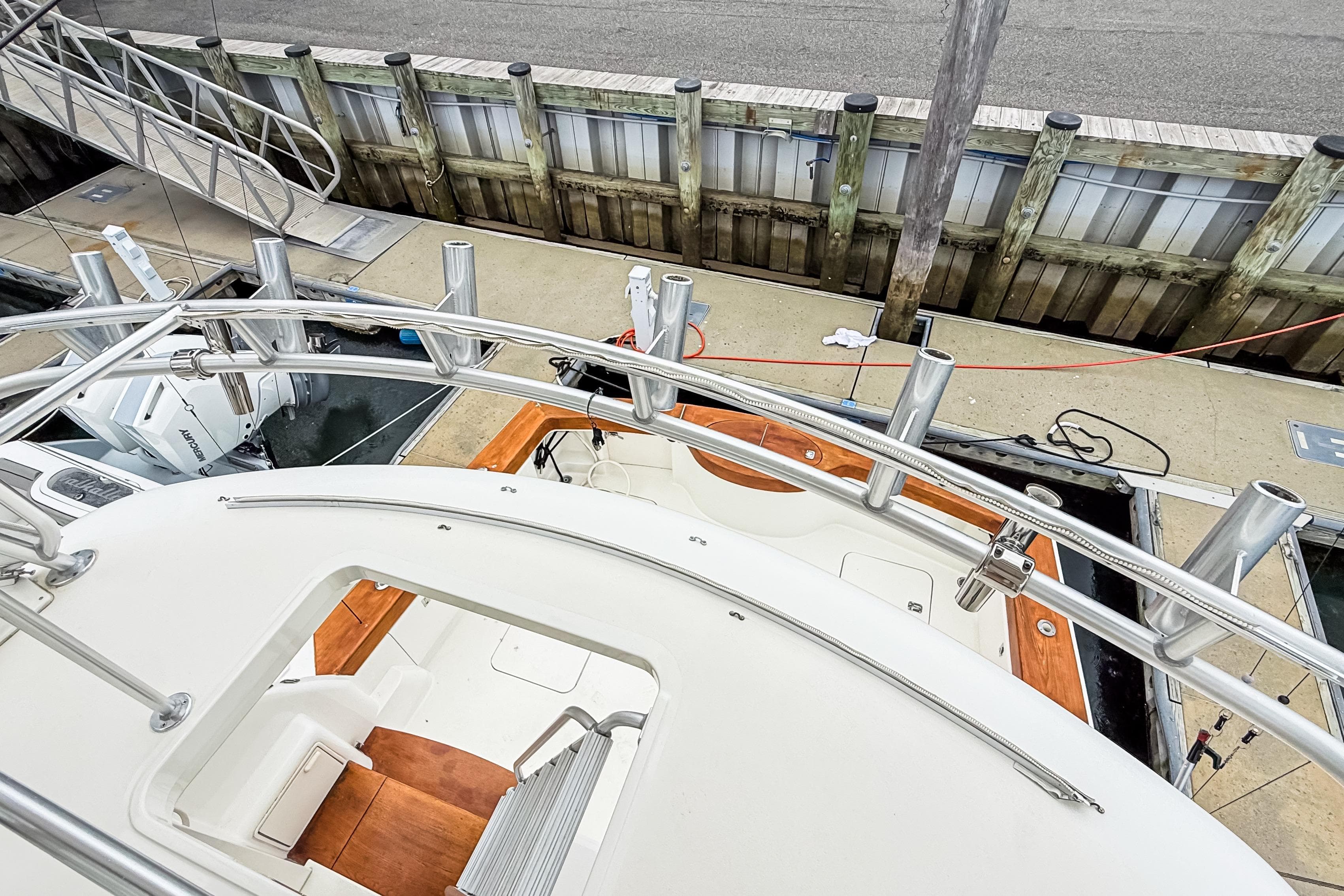 2004 Ocean Yachts 50 Super Sport docked, view from upper deck, showcasing sleek design.