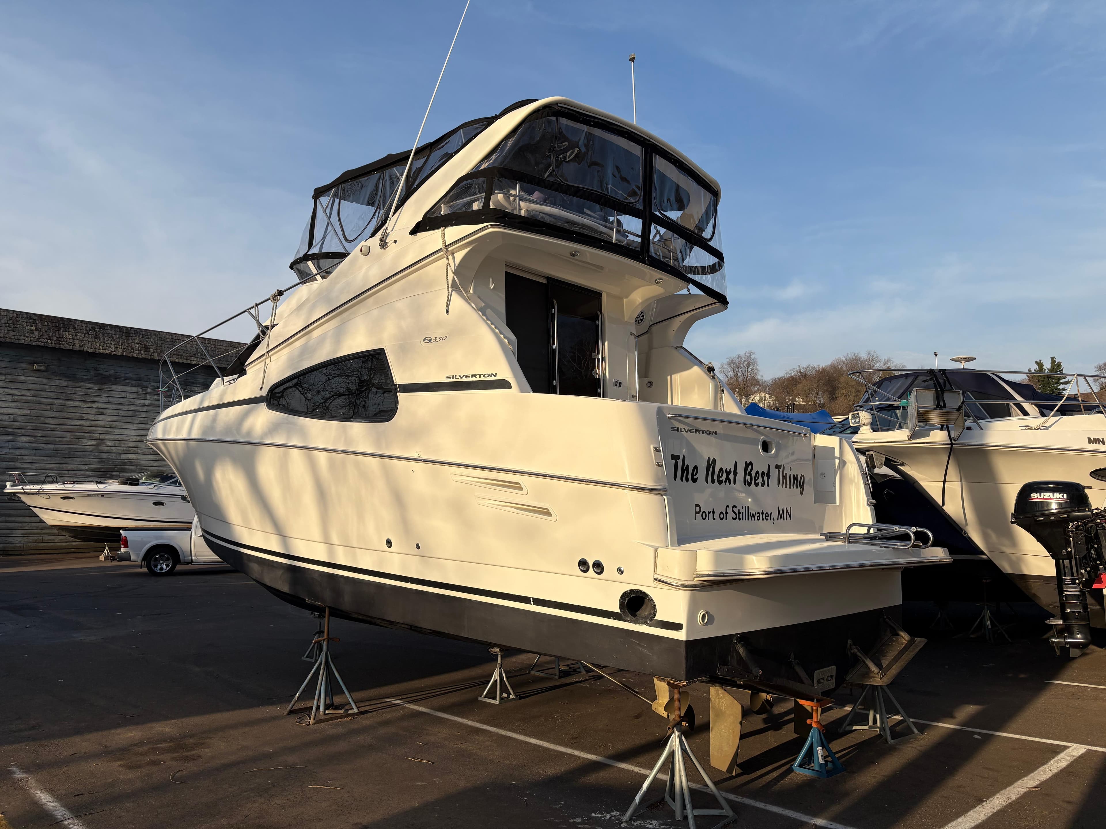 2000 Silverton 330 Sport Bridge yacht on stands, outdoor display.