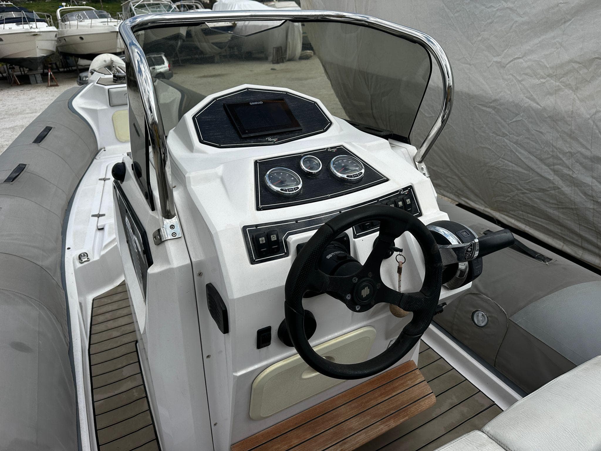 2021 Ranieri Cayman 26 boat dashboard with steering wheel and control panel.