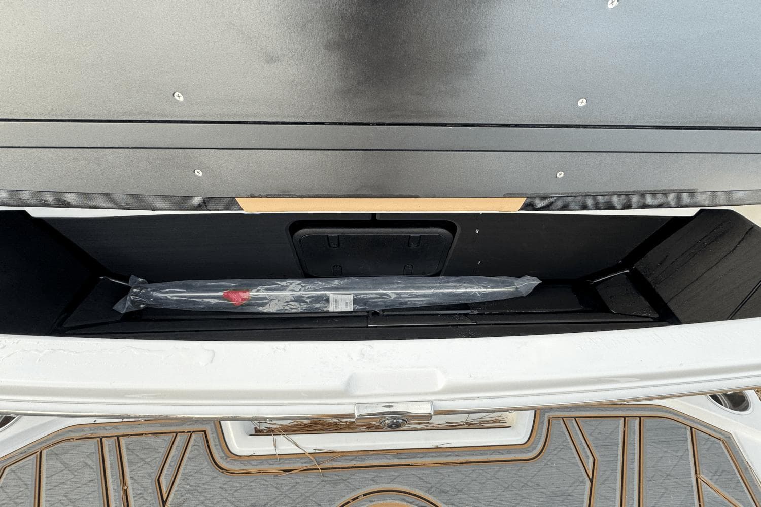 2024 Tigé RZX22 boat storage compartment with packaged accessory.