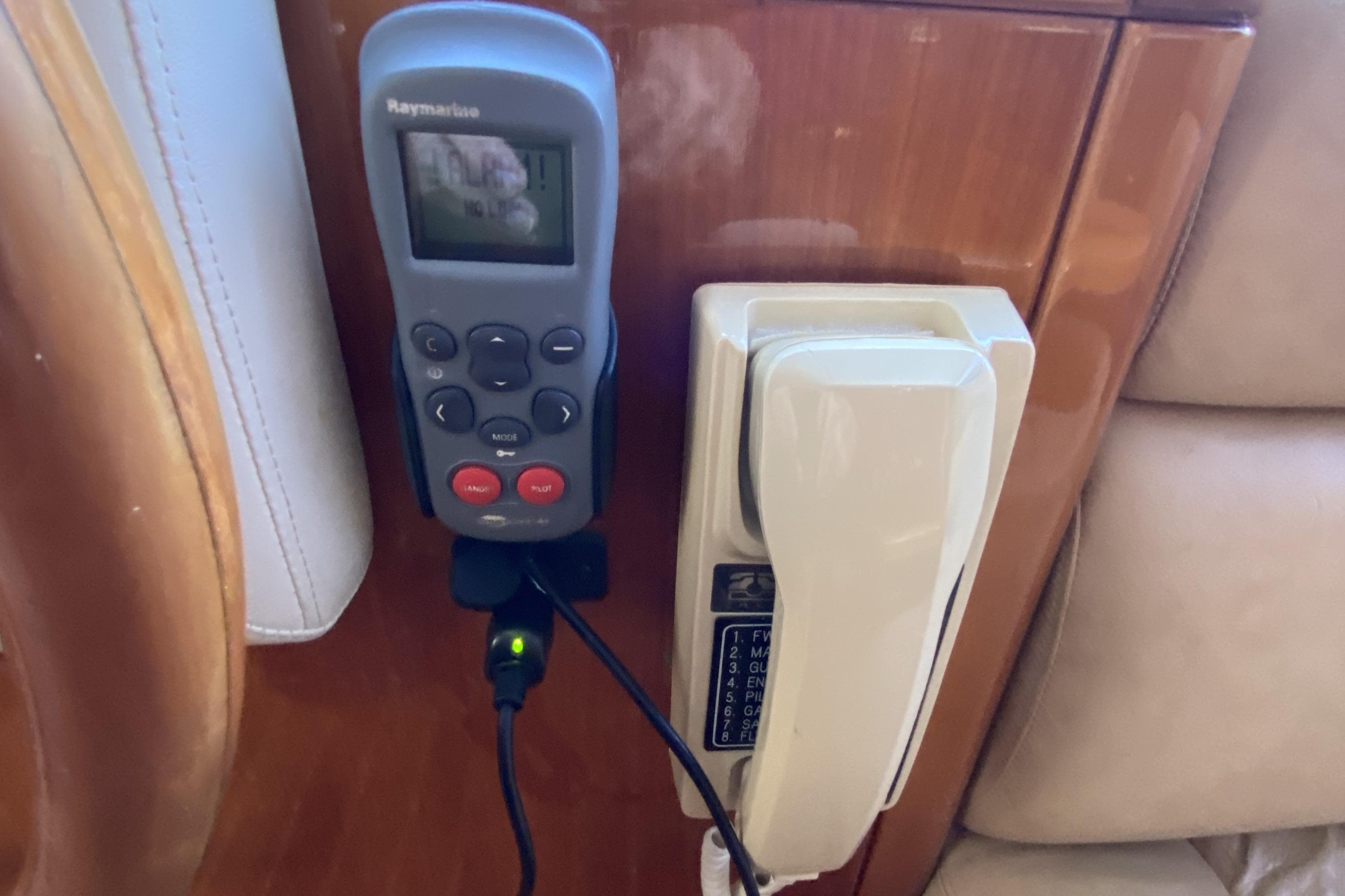 Remote control and phone mounted on wooden panel in Compass 55, 2000 model.