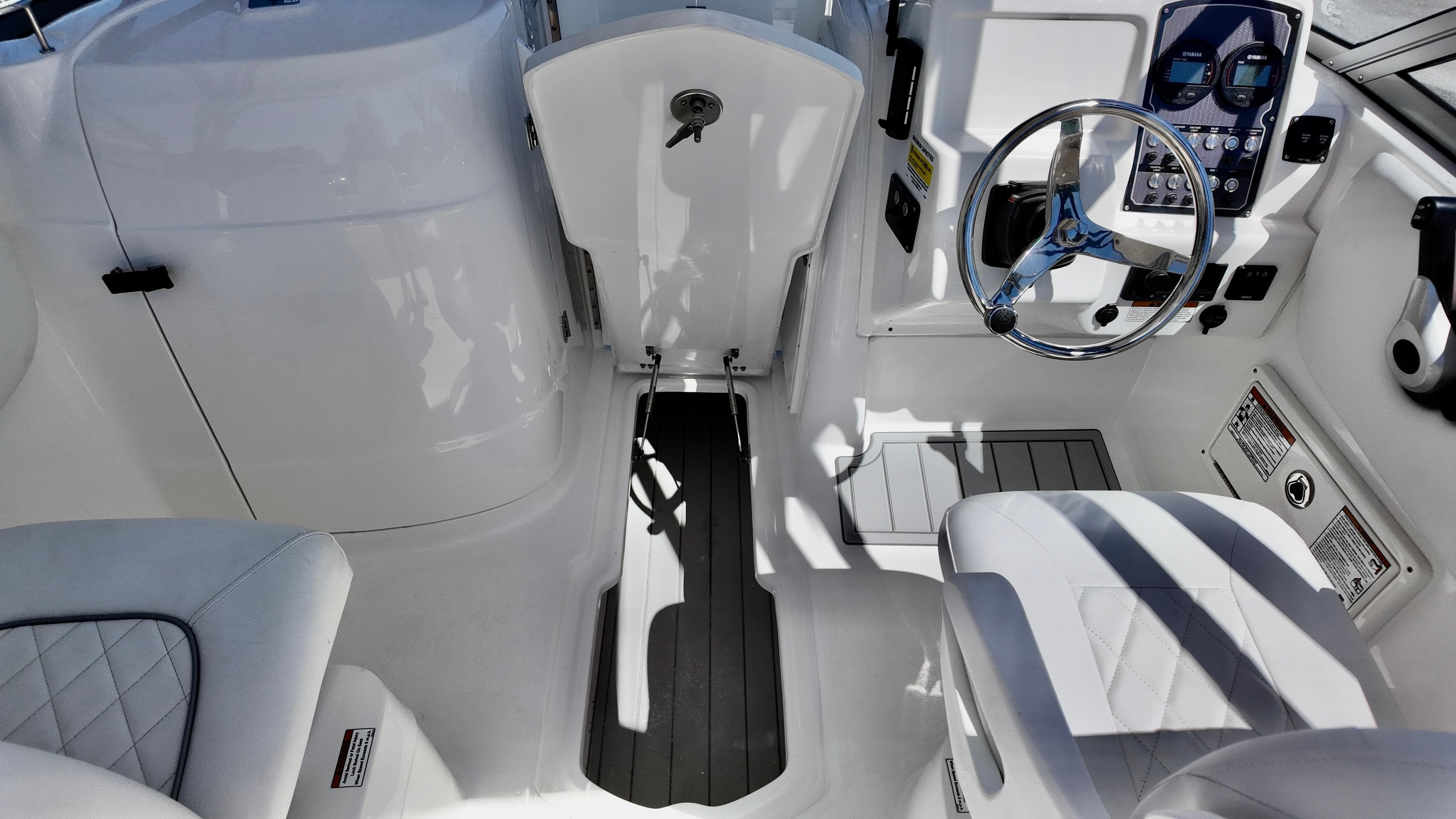 Interior view of 2025 Sea Fox 228 Traveler boat, featuring sleek white seating and modern controls.