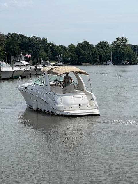 2005 Sea Ray 280 Sundancer cruising on a calm river near a marina.