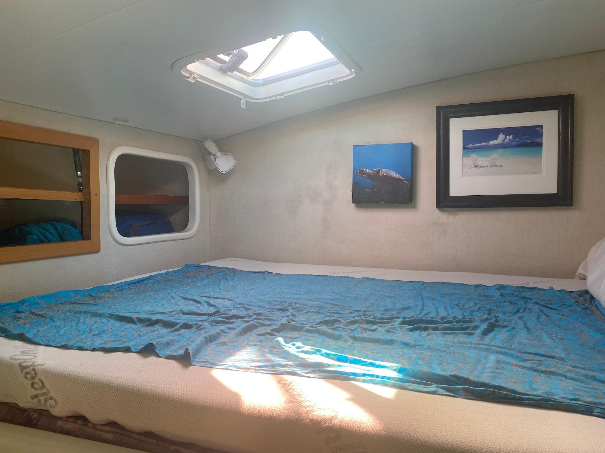 Cozy cabin interior of 1995 Voyage Mayotte 47 with skylight and wall art.