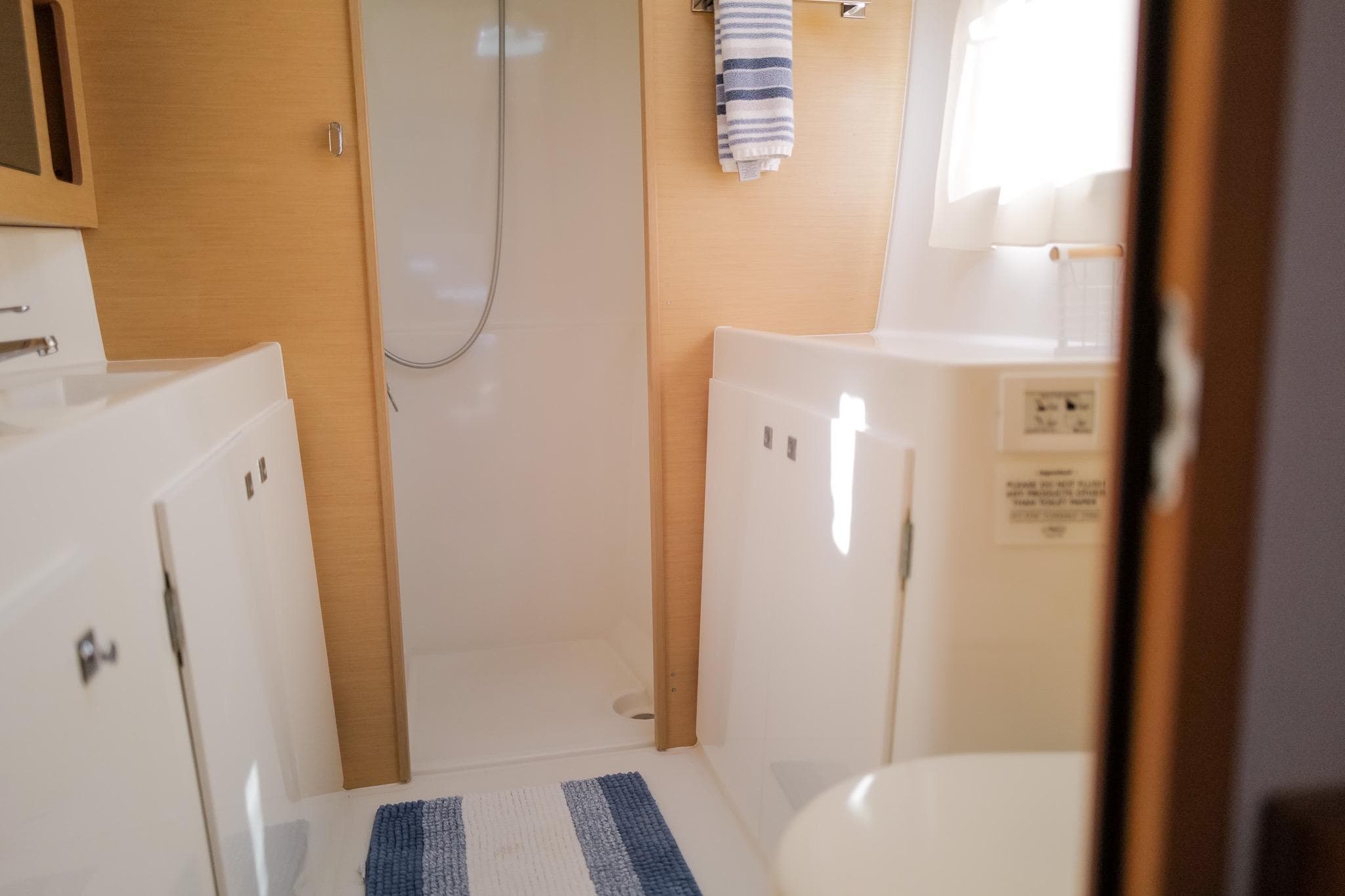 Interior of 2018 Lagoon 42 yacht bathroom with shower and striped towel.