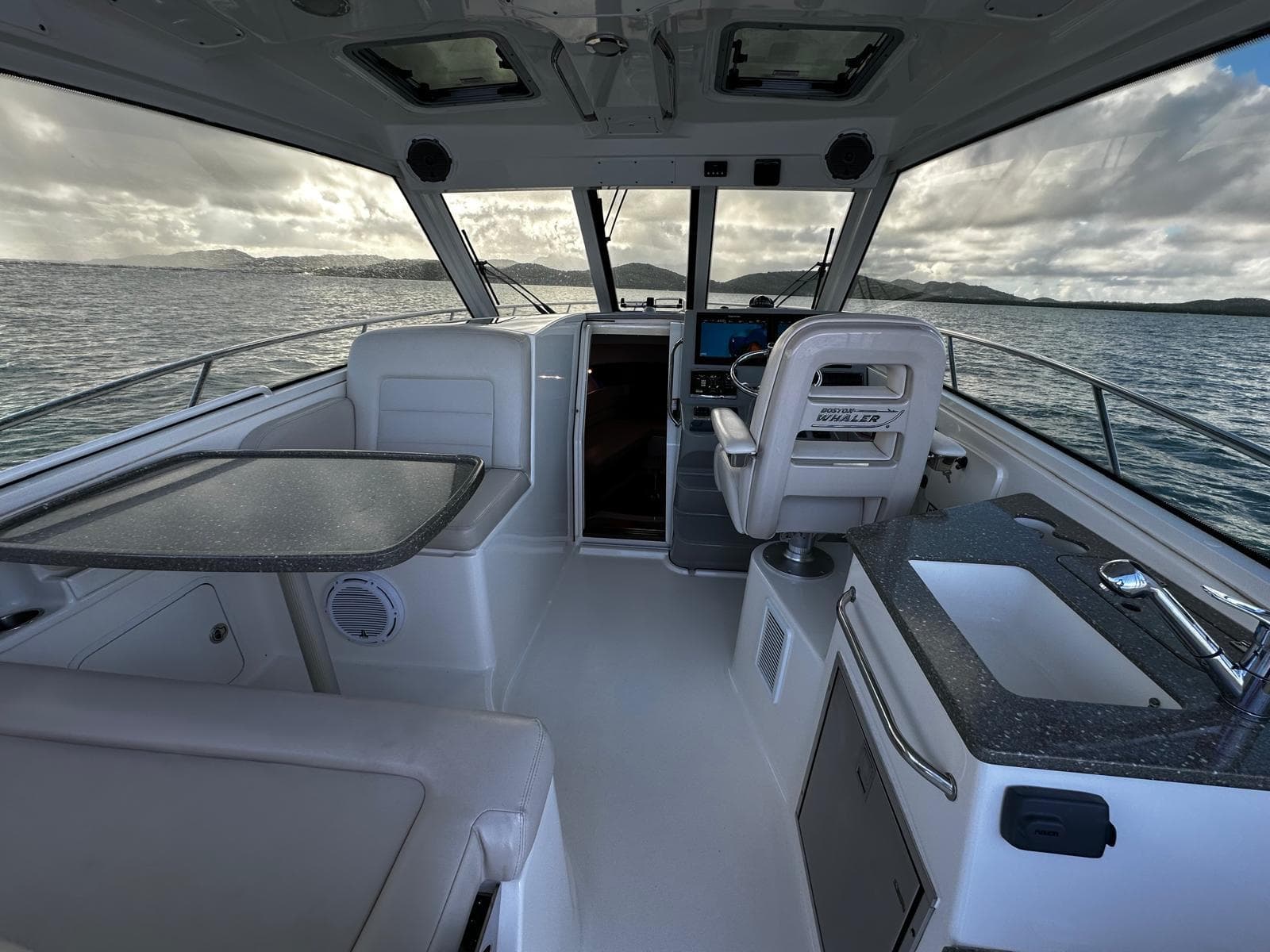 Interior of 2015 Boston Whaler 345 Conquest boat with seating and helm.