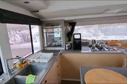 Modern kitchen interior of 2019 Fountaine Pajot SABA 50 catamaran with appliances and large windows.