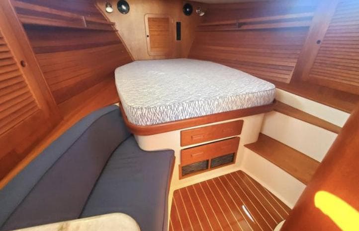 2018 Hinckley Picnic Boat 37 MKIII cabin with cozy bed and wooden interior.