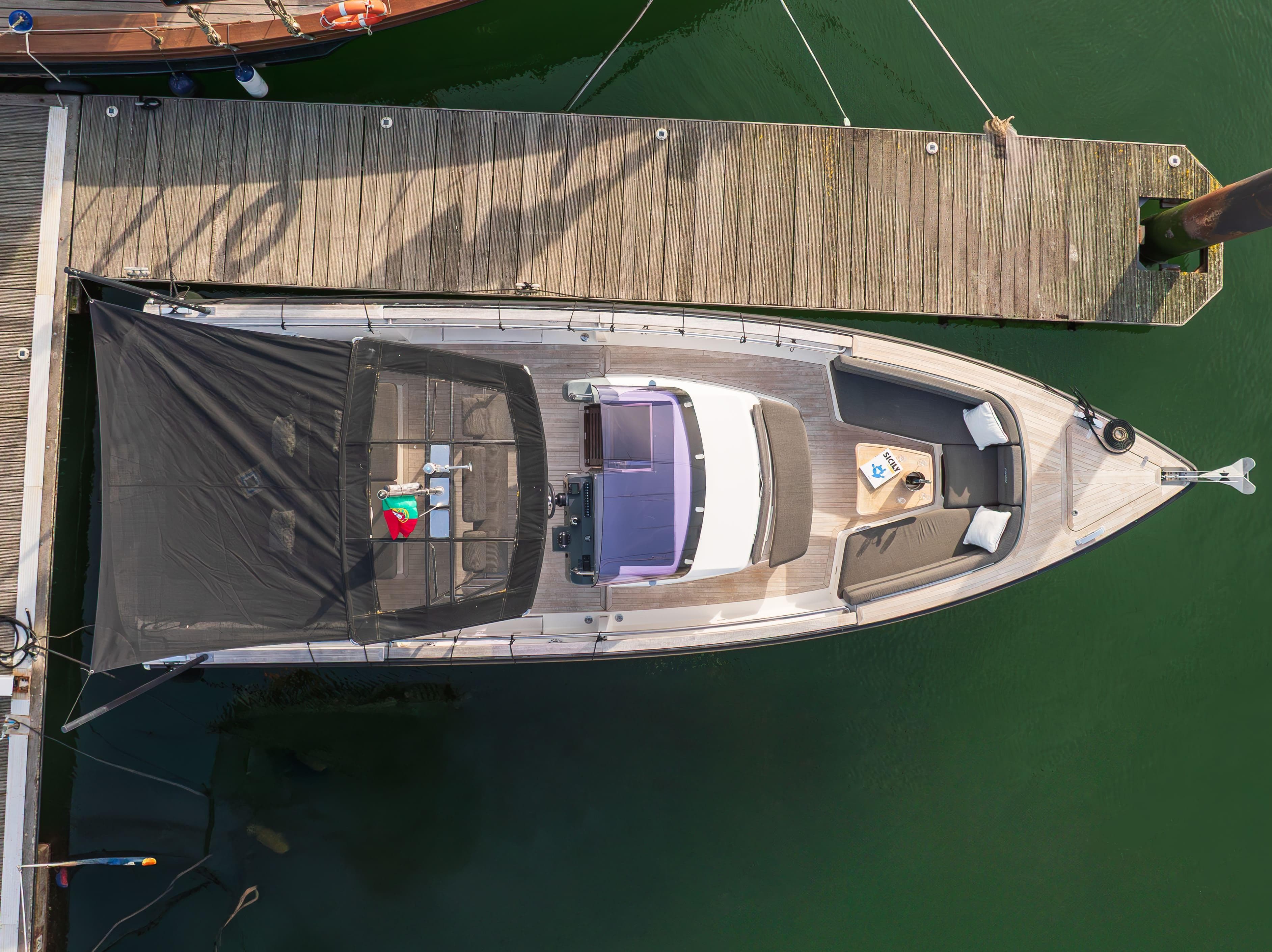 Aerial view of 2011 Fjord 36' Open yacht docked at a wooden pier.