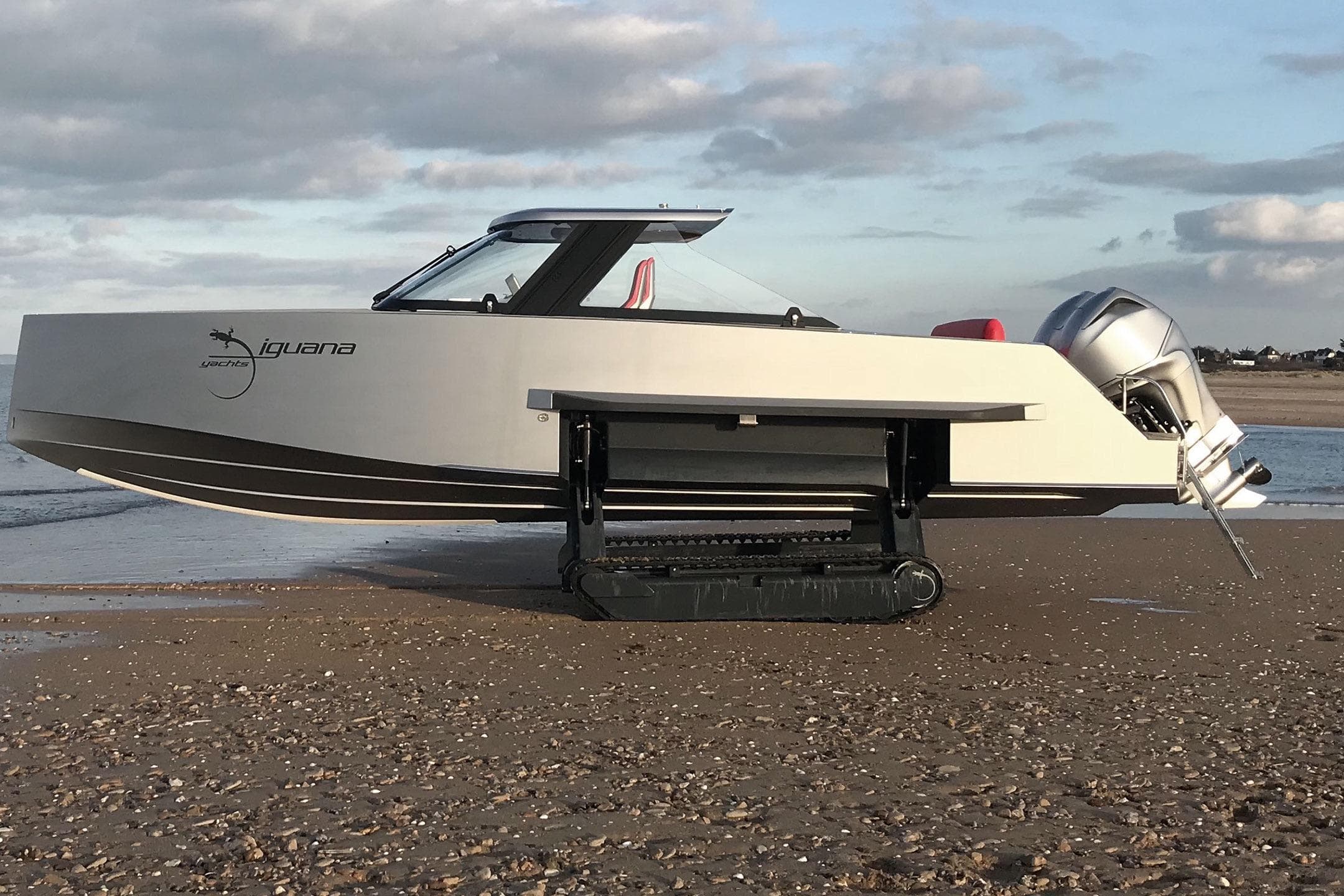 2019 IGUANA Yachts 29 amphibious boat on sandy beach with tracks extended.