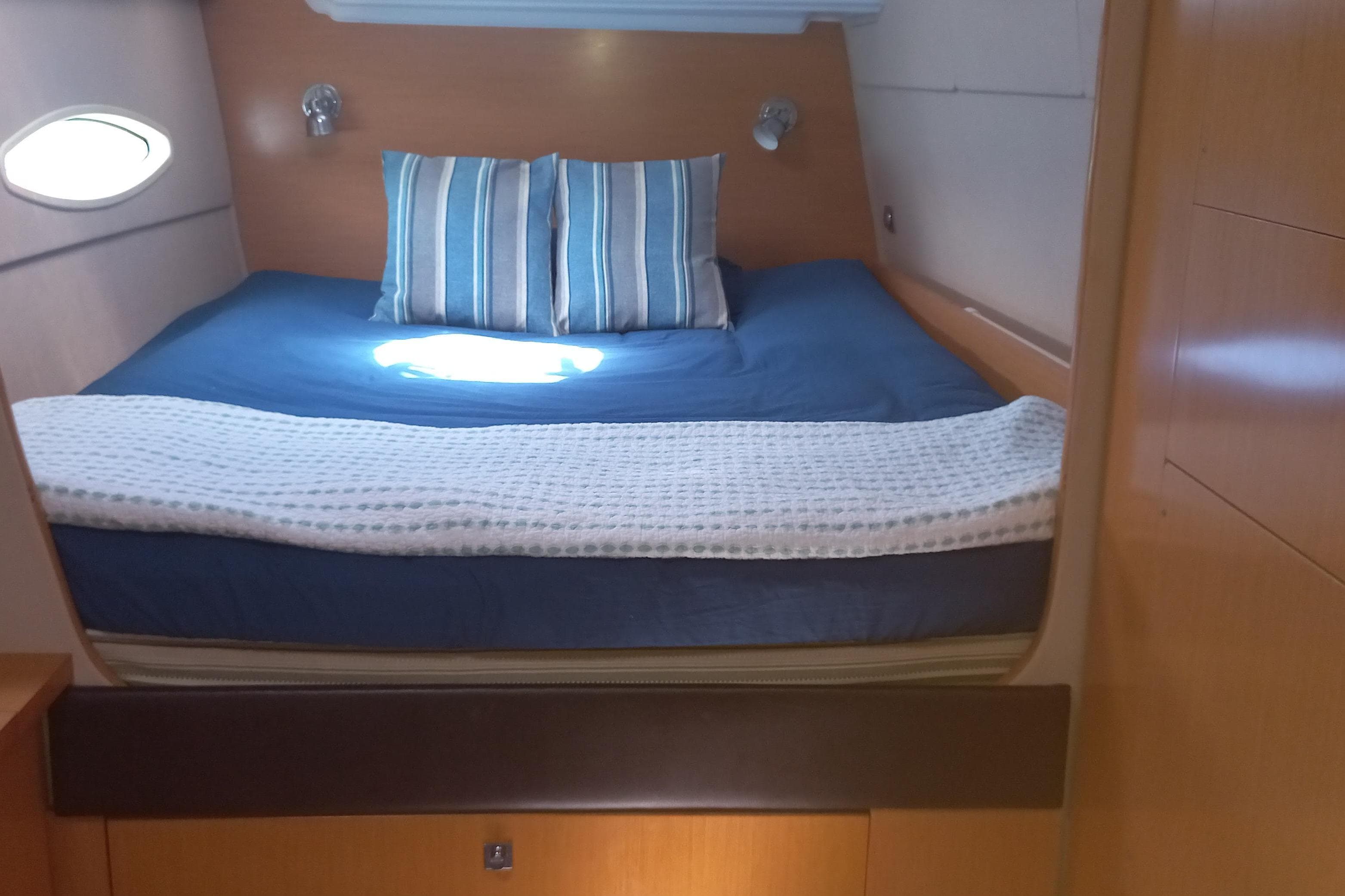 Cozy cabin interior of 2010 Fountaine Pajot Lipari 41 catamaran with blue bedding.