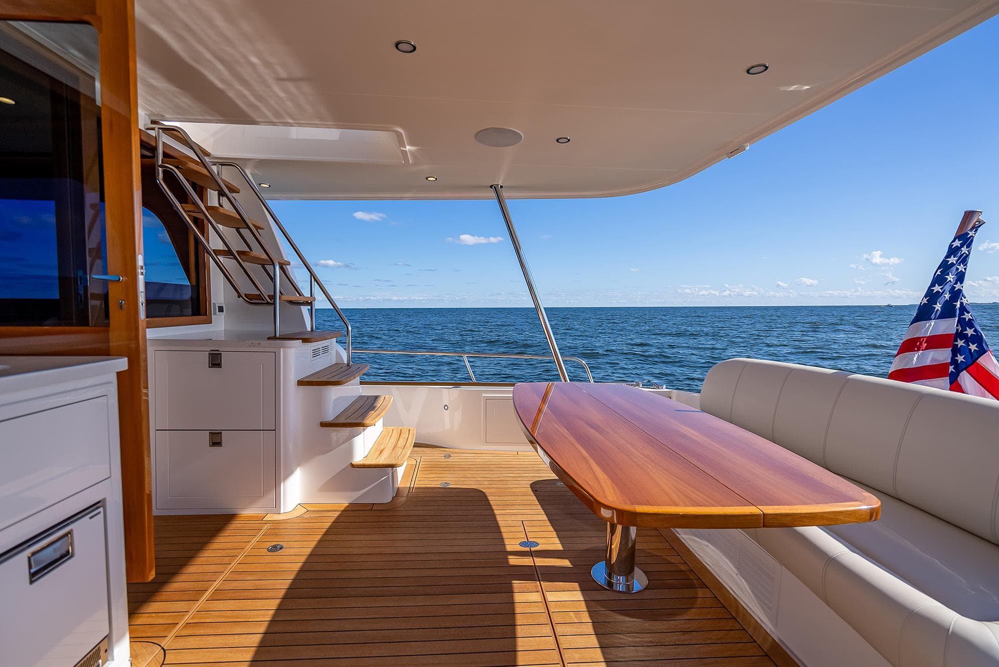2026 Grand Banks GB 54 yacht deck with seating, table, and ocean view.