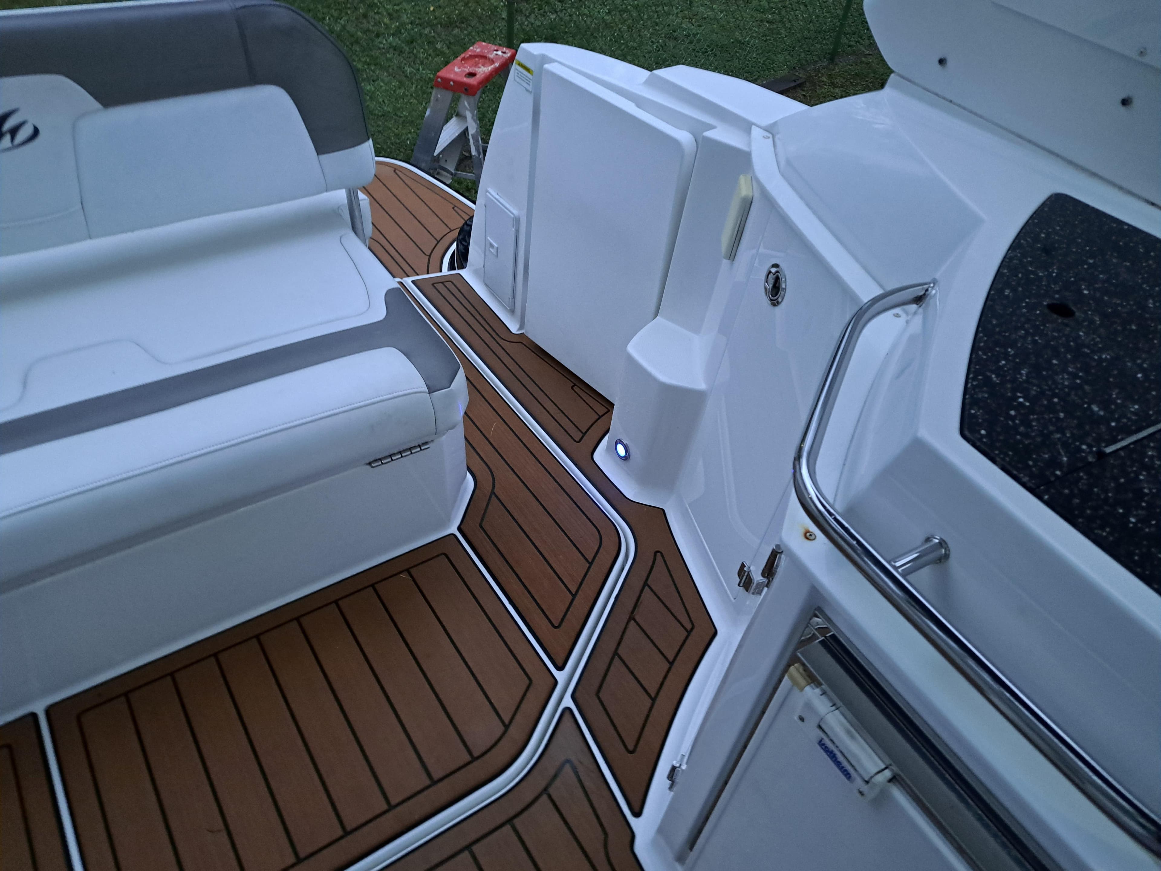 2015 Monterey 295 Sport Yacht interior with teak flooring and white seating.