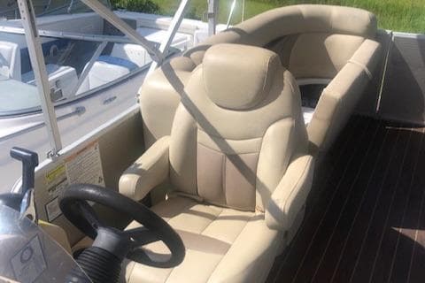 2018 Godfrey Sweetwater 2286C boat interior with beige seating and steering wheel.