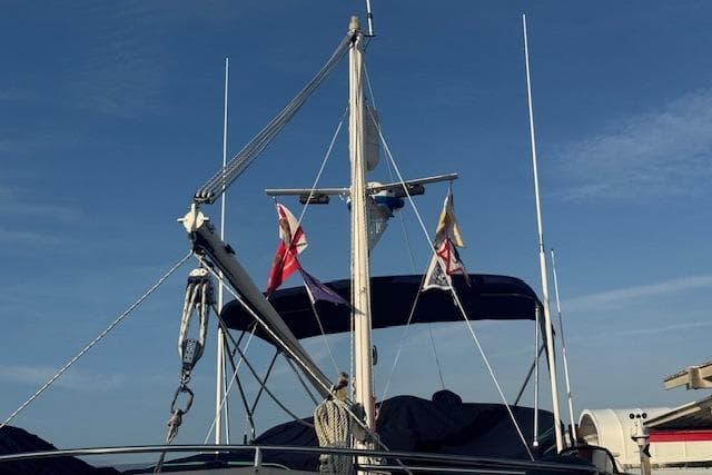 1986 Krogen 42 Classic yacht with flags against a clear blue sky.