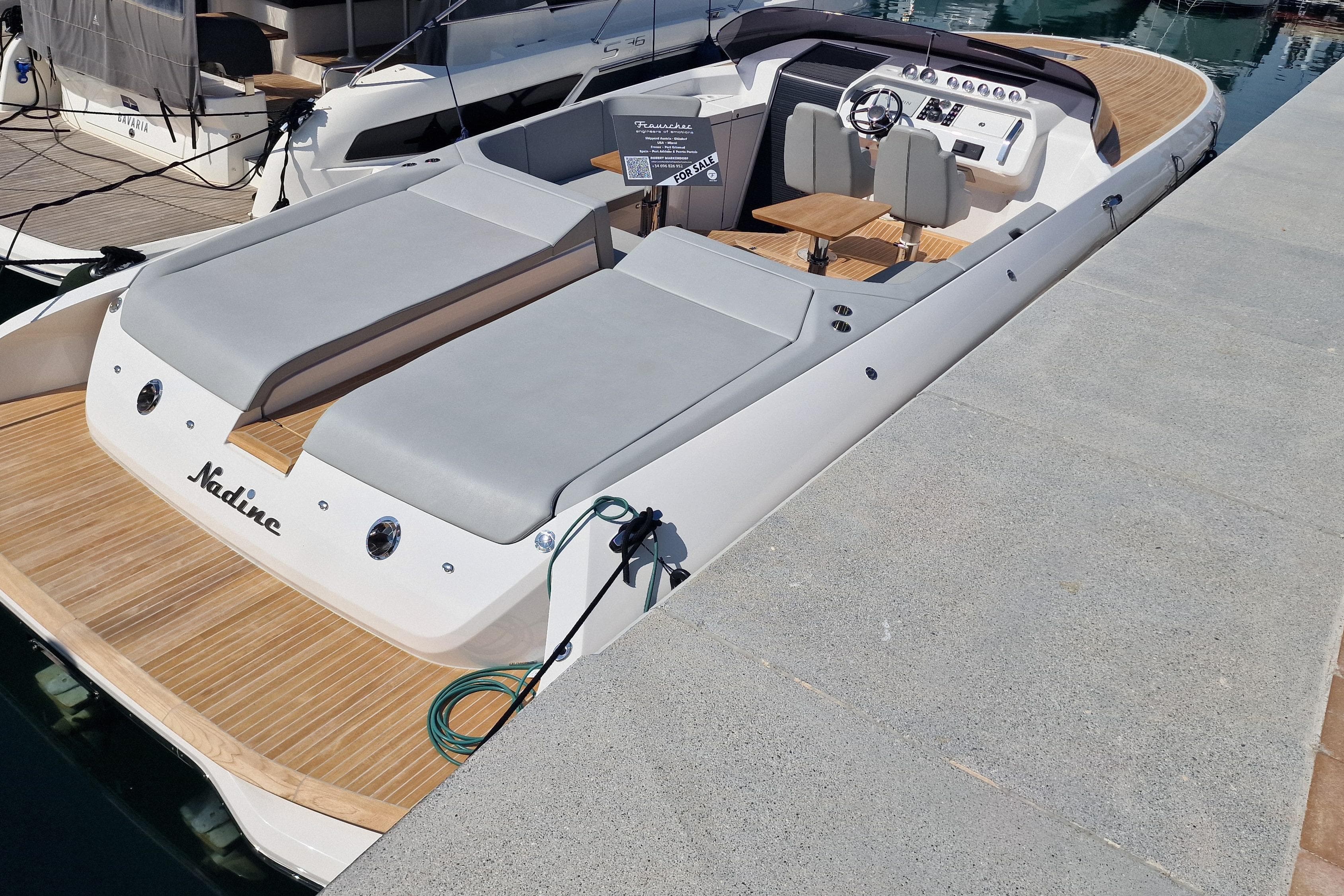 2022 Frauscher 1212 Ghost luxury boat docked with sleek design and spacious seating.