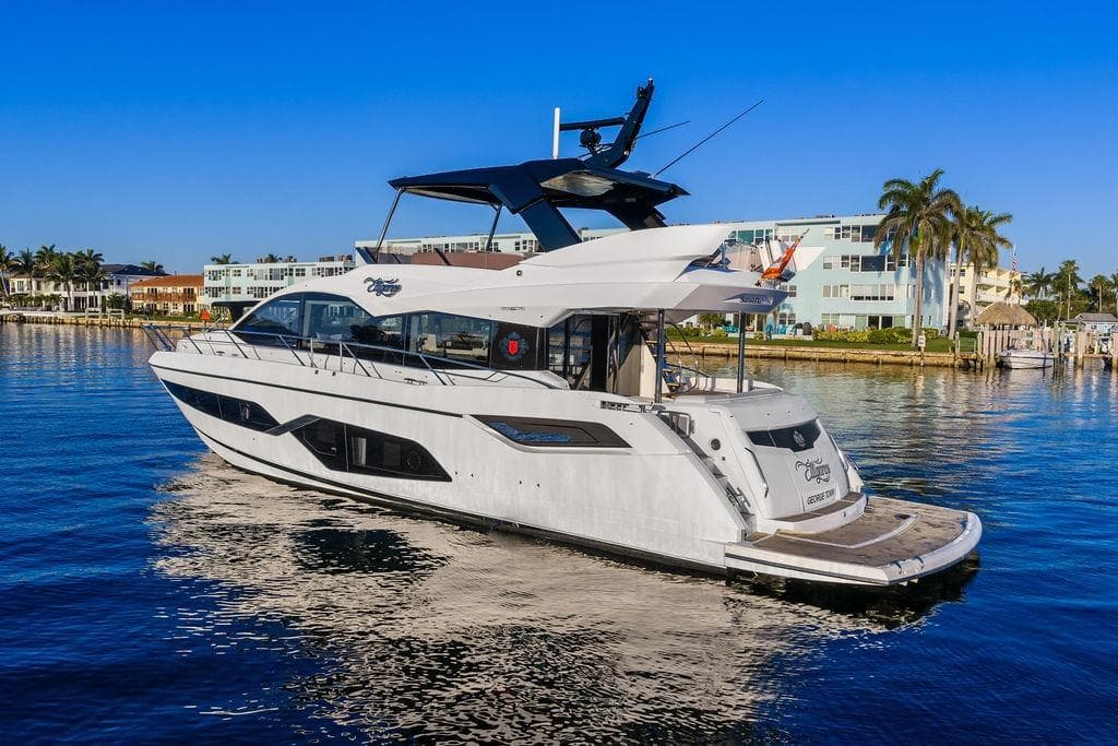 Luxury Sunseeker Manhattan 68 yacht, 2021 model, cruising in a scenic waterfront setting.