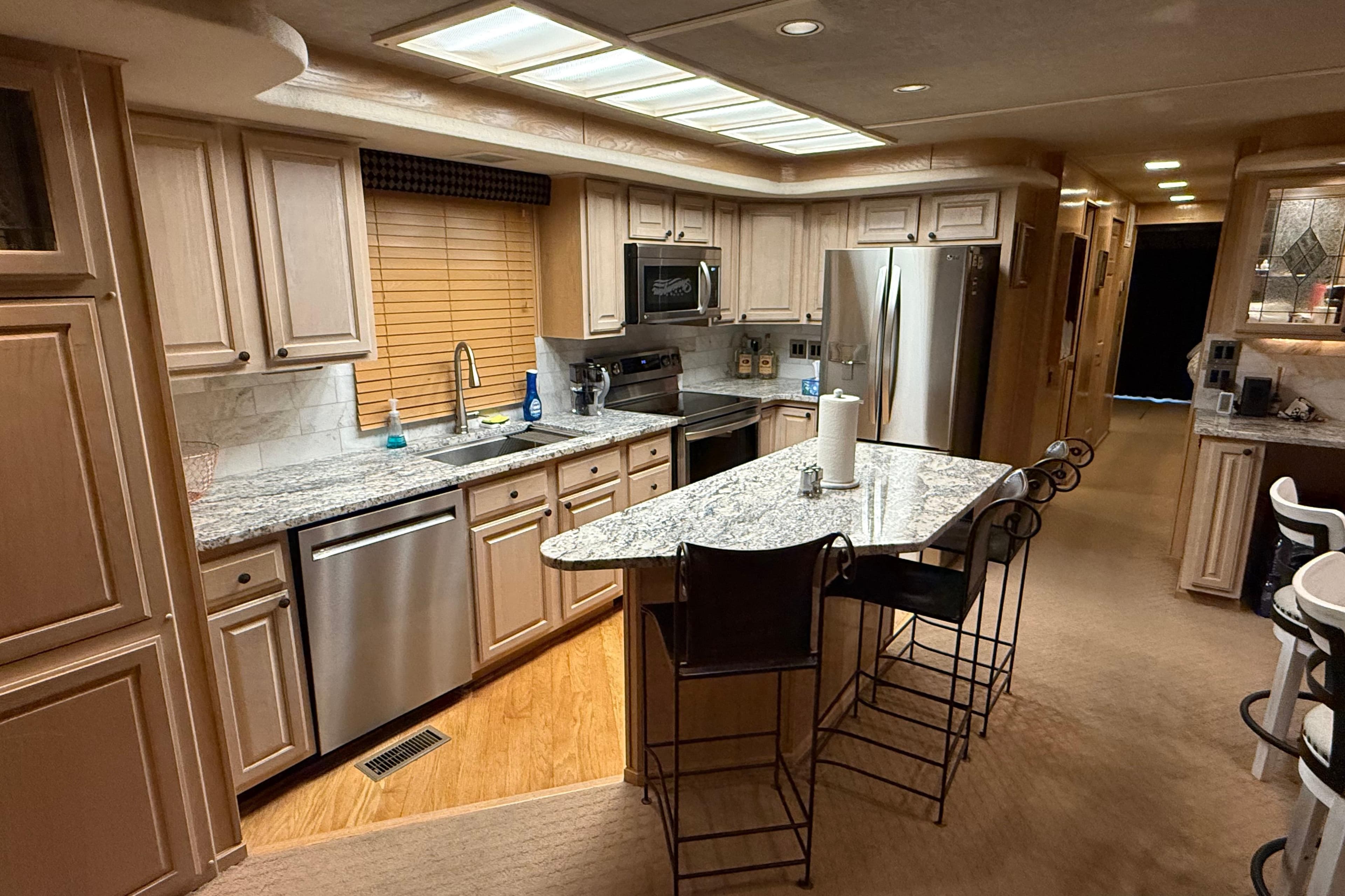Luxurious kitchen interior of a 1998 Sumerset 16x76 houseboat with modern appliances and granite countertops.