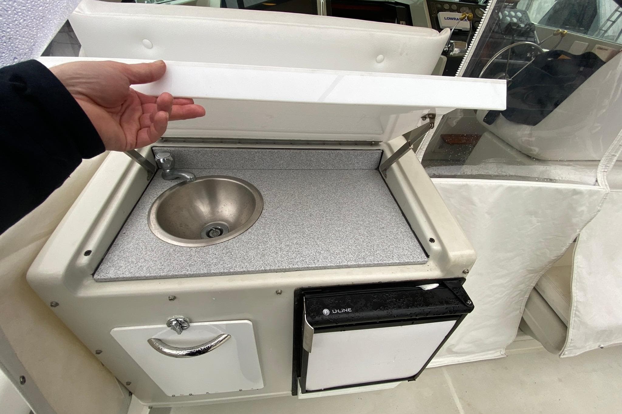 1988 Tiara 3300 Open boat kitchenette with sink and mini fridge.