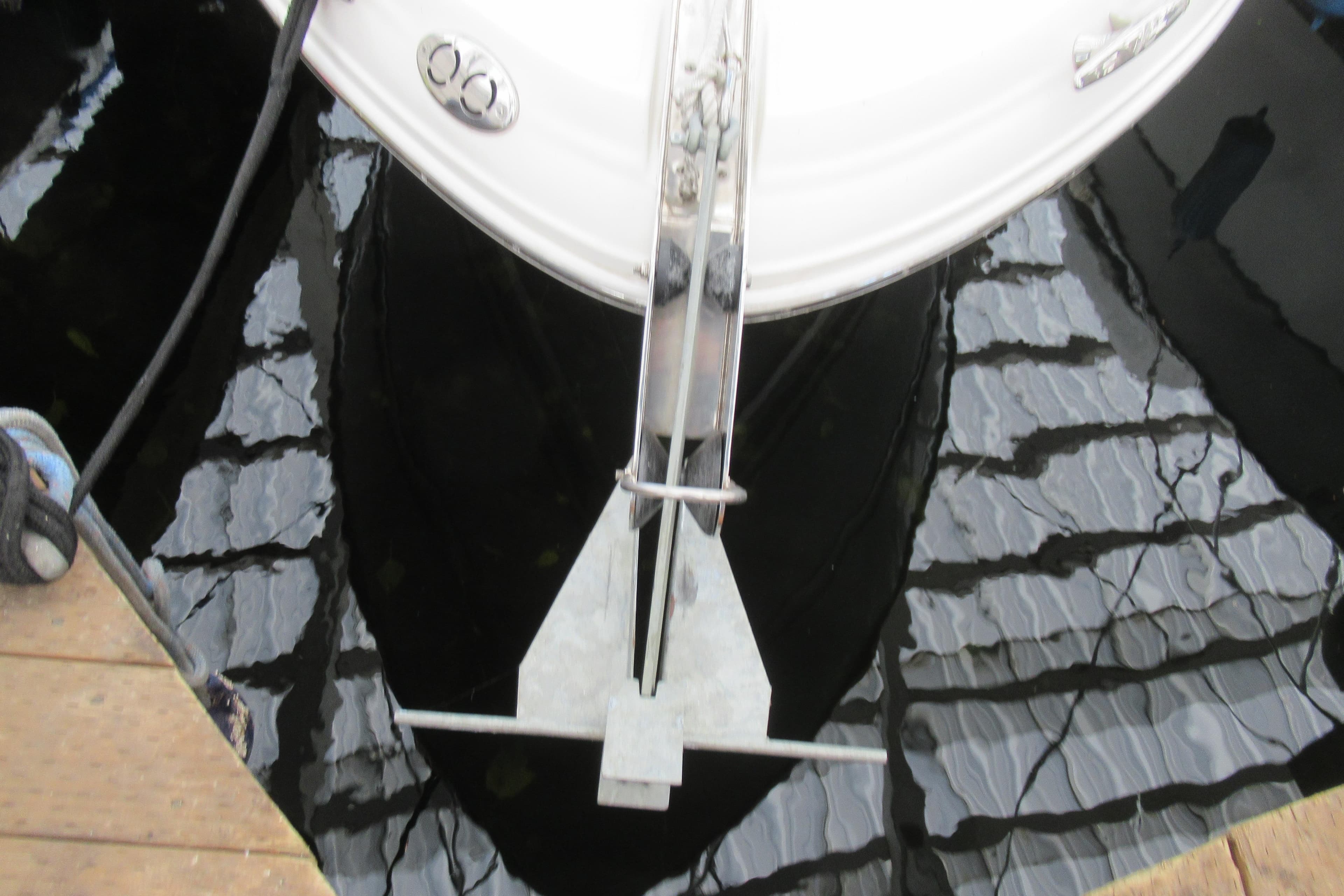 Bow view of 2001 Searay 280 Sundancer with anchor, docked on reflective water.