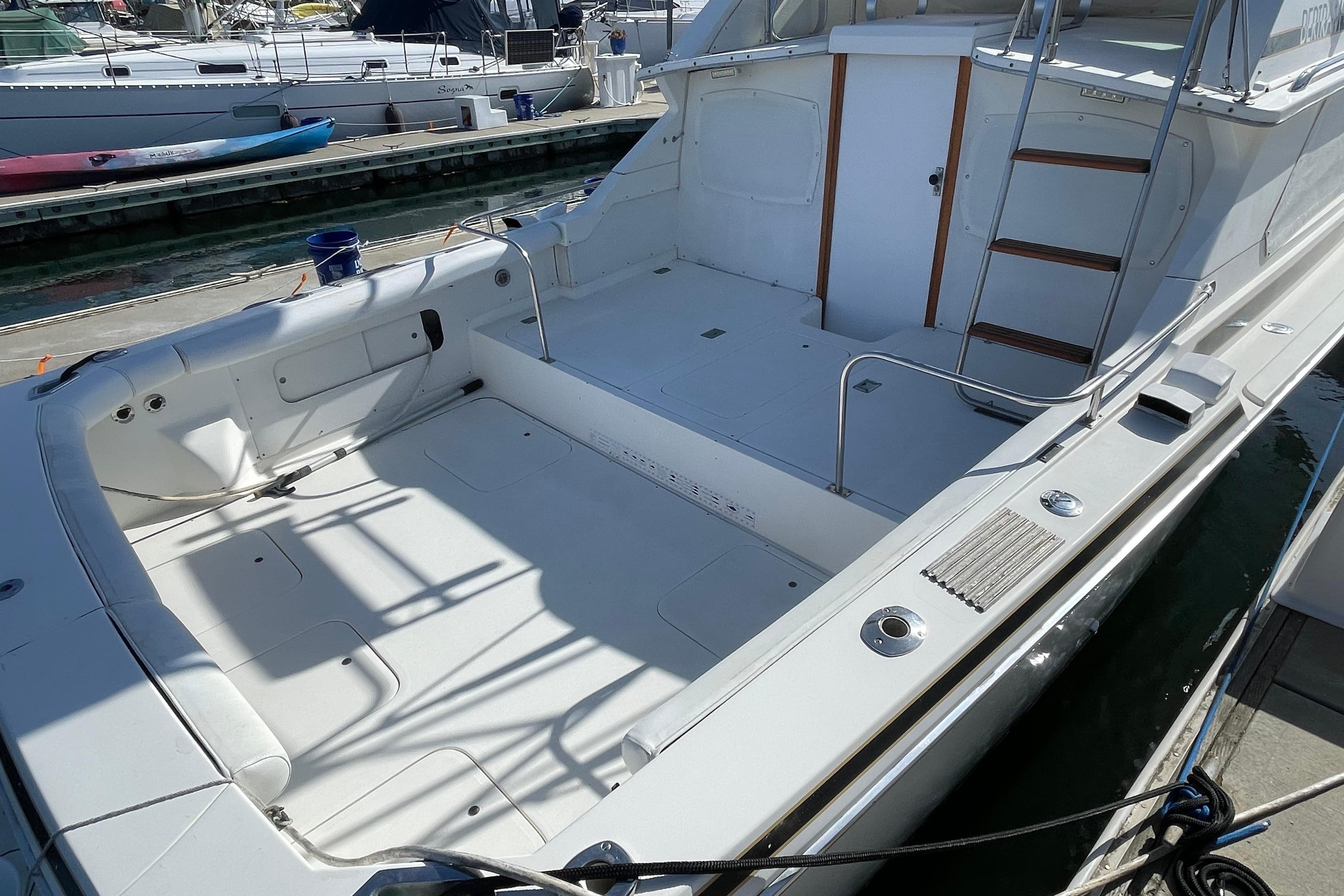 1987 Bertram 28 Flybridge boat with spacious deck, docked at marina.