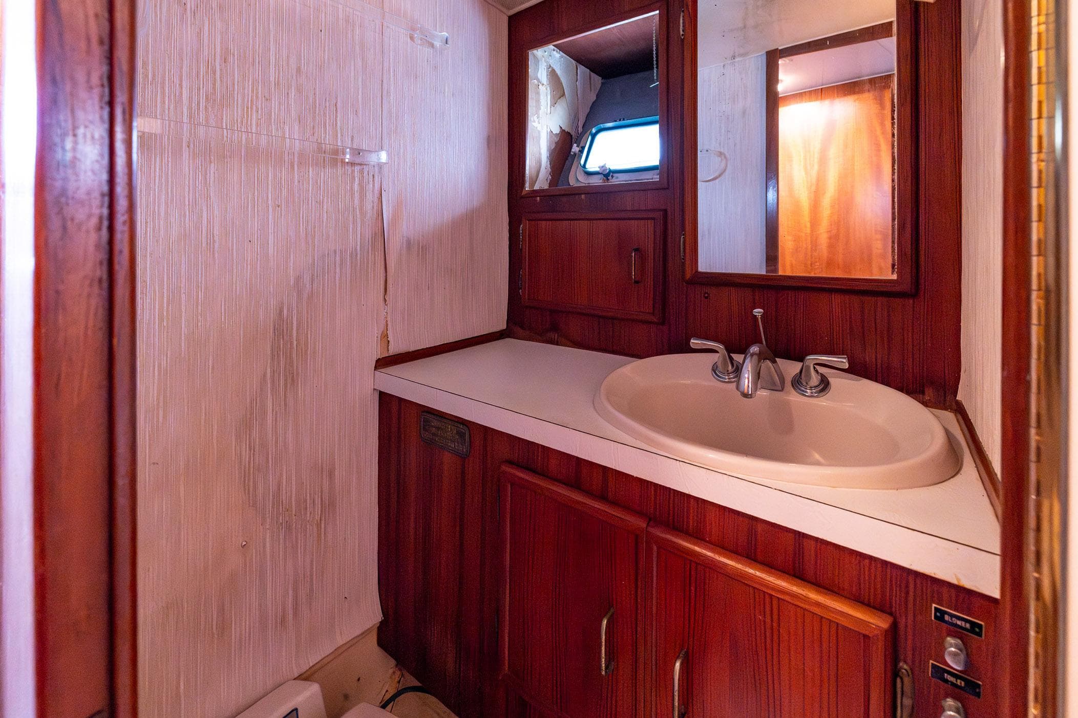 1982 Post 46 Convertible yacht bathroom with wooden cabinetry and sink.