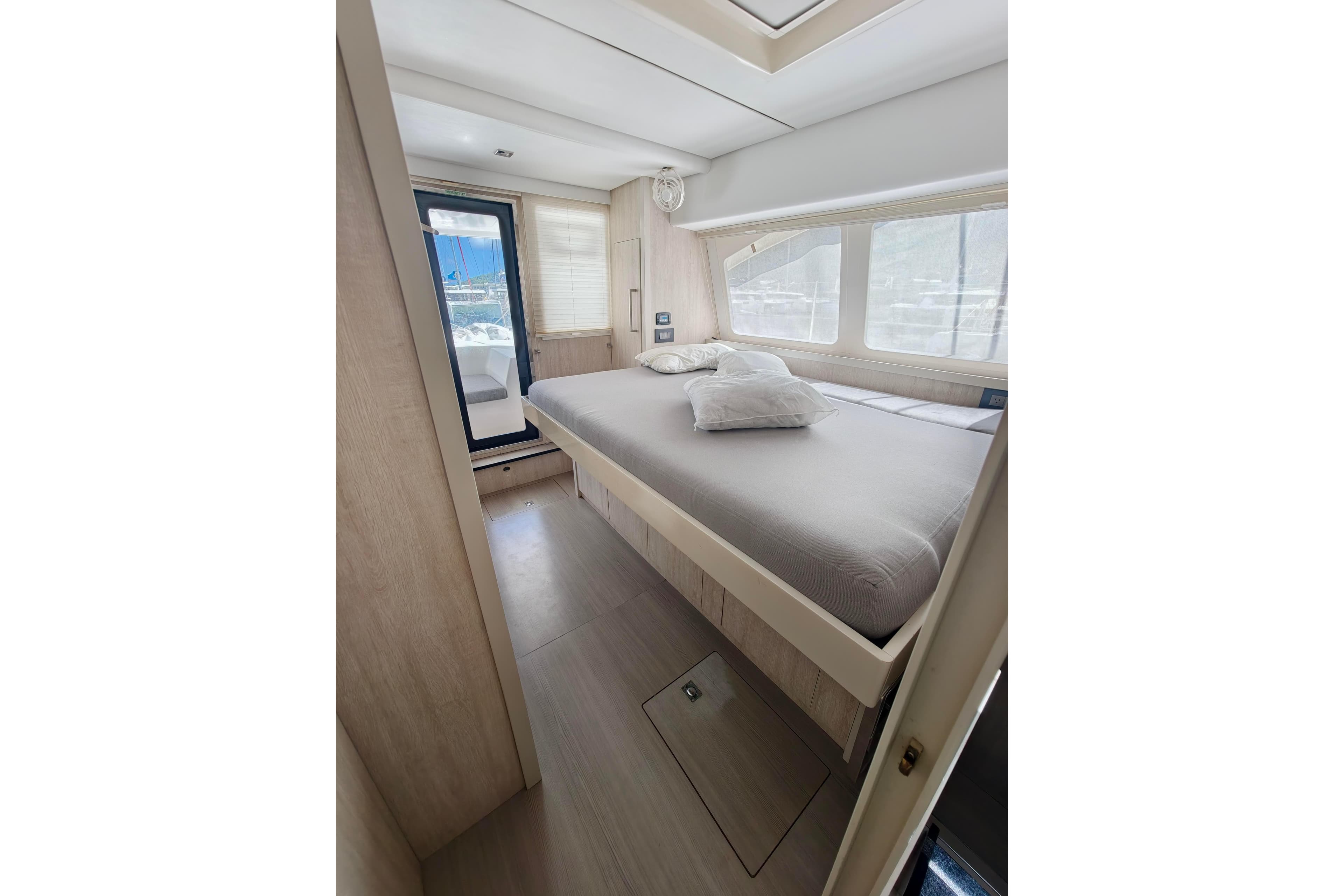 Luxurious bedroom interior of 2020 Leopard 58 yacht with large windows and modern design.