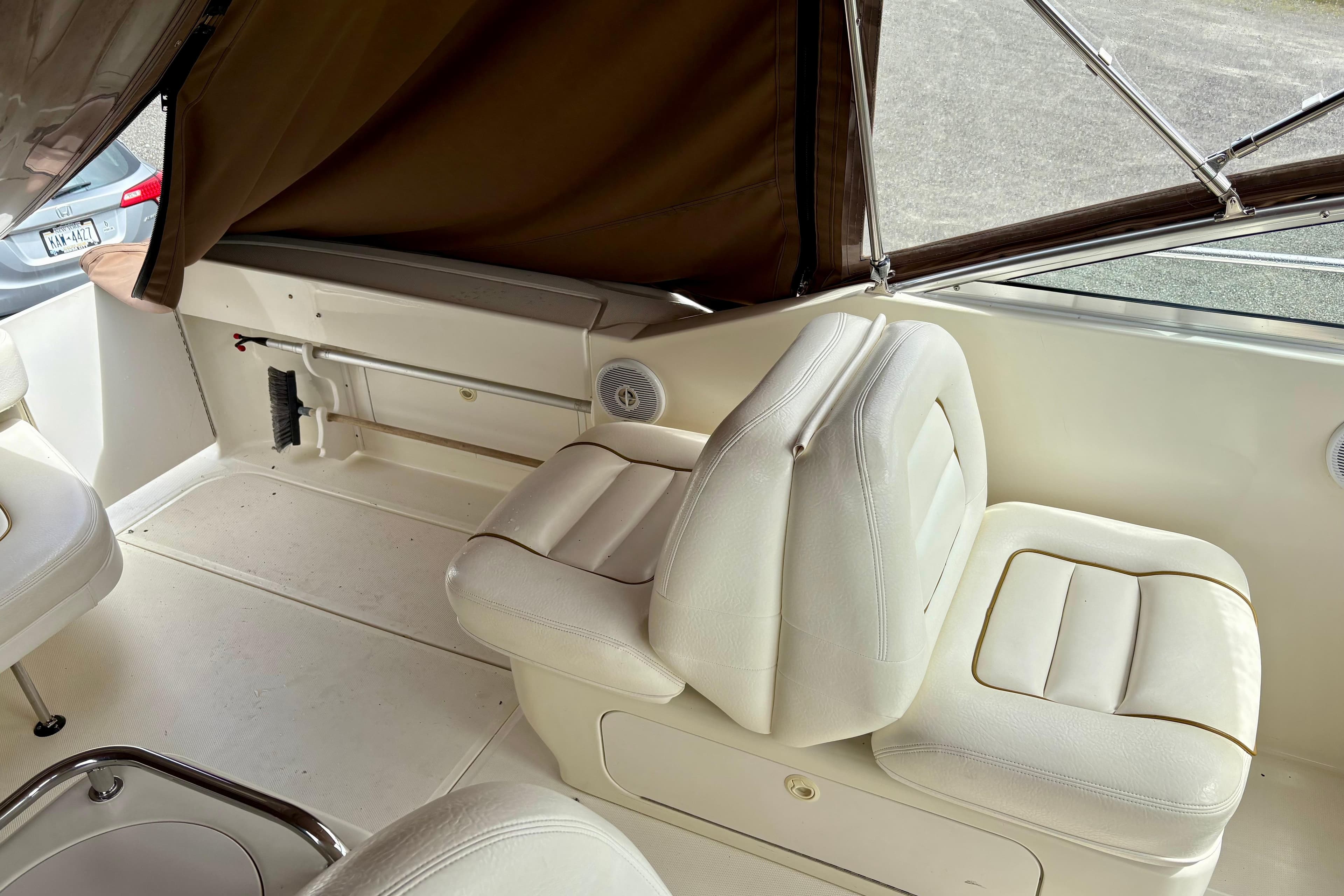 Interior of 2000 Sea Ray 290 Amberjack boat with white seating and brown canopy.