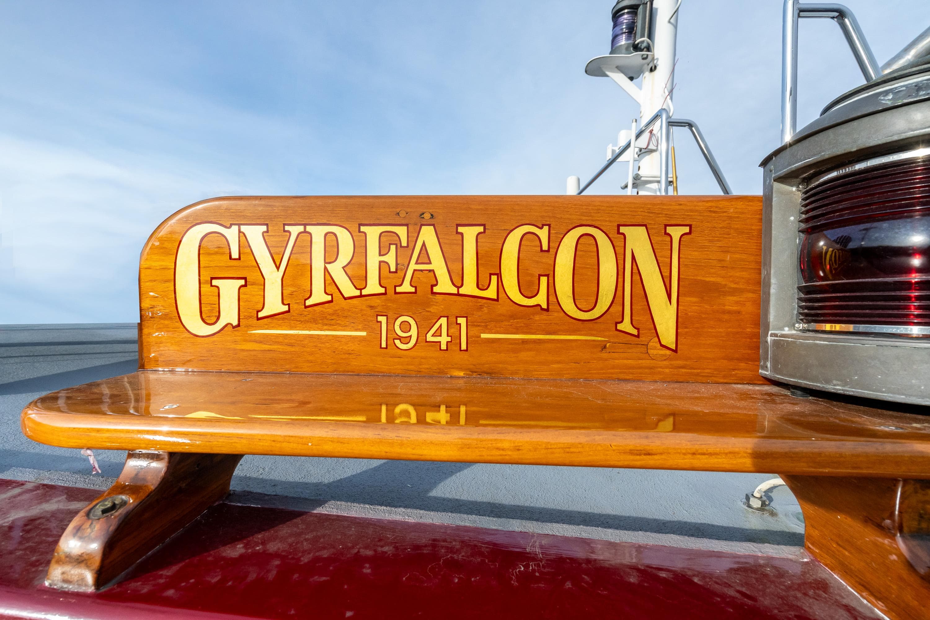 Wooden nameplate on 1941 Custom Sagstad Fantail boat, "GYRFALCON," with polished finish.
