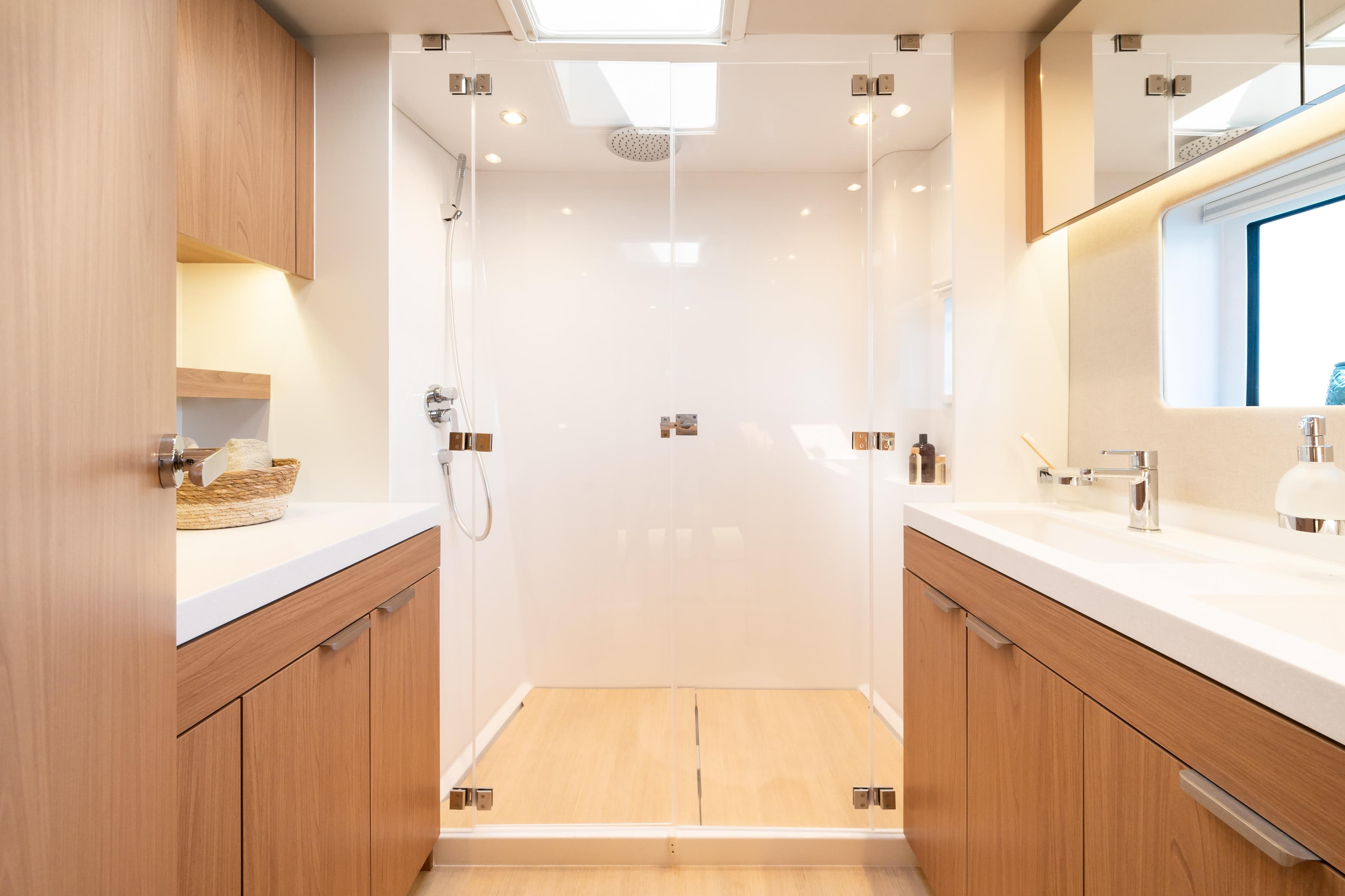 Modern bathroom in 2026 Bali 5.8 yacht with wood cabinets and glass shower.