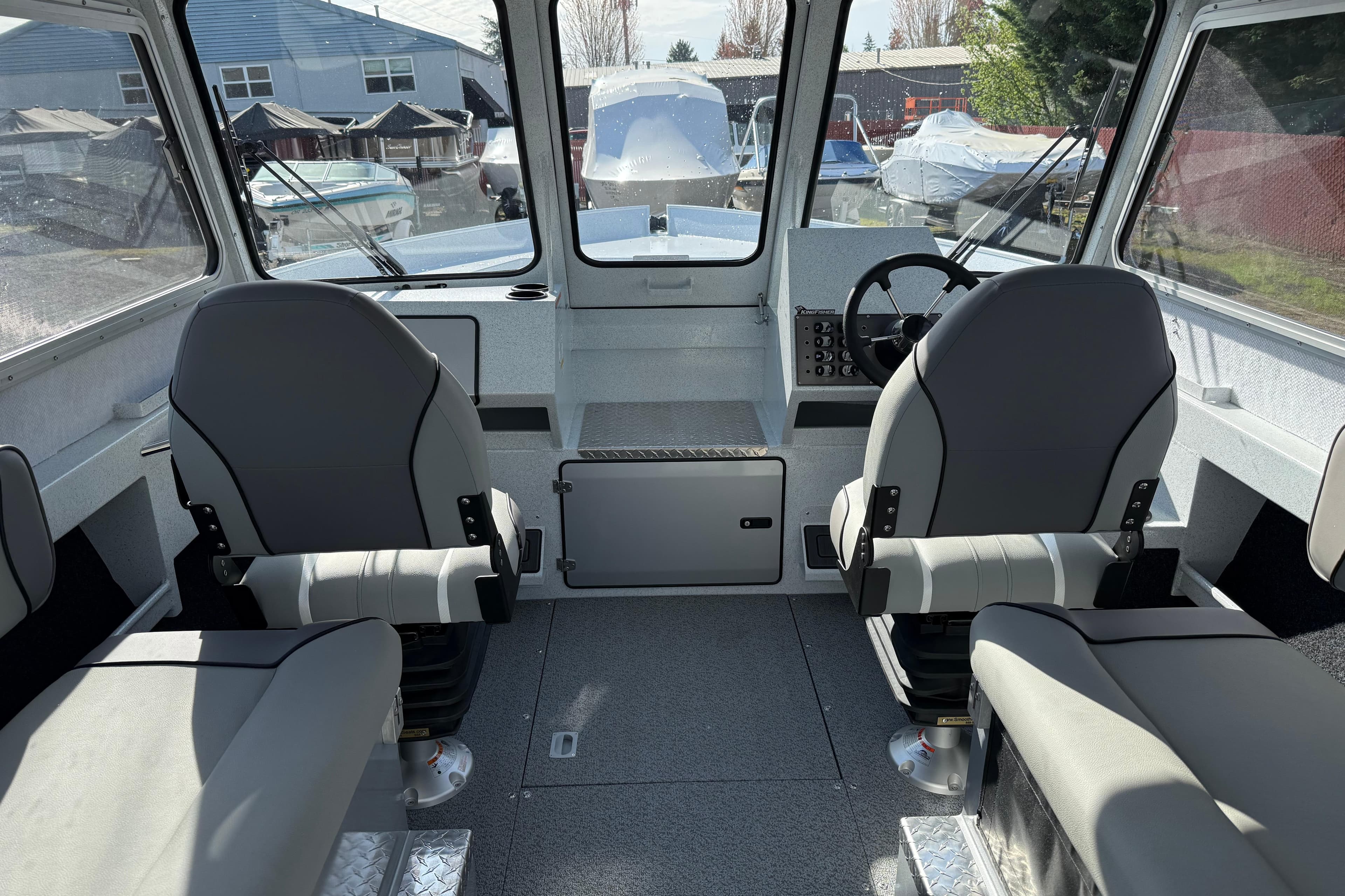 Interior of 2026 KingFisher 2425 Escape HT boat with dual seats and steering console.