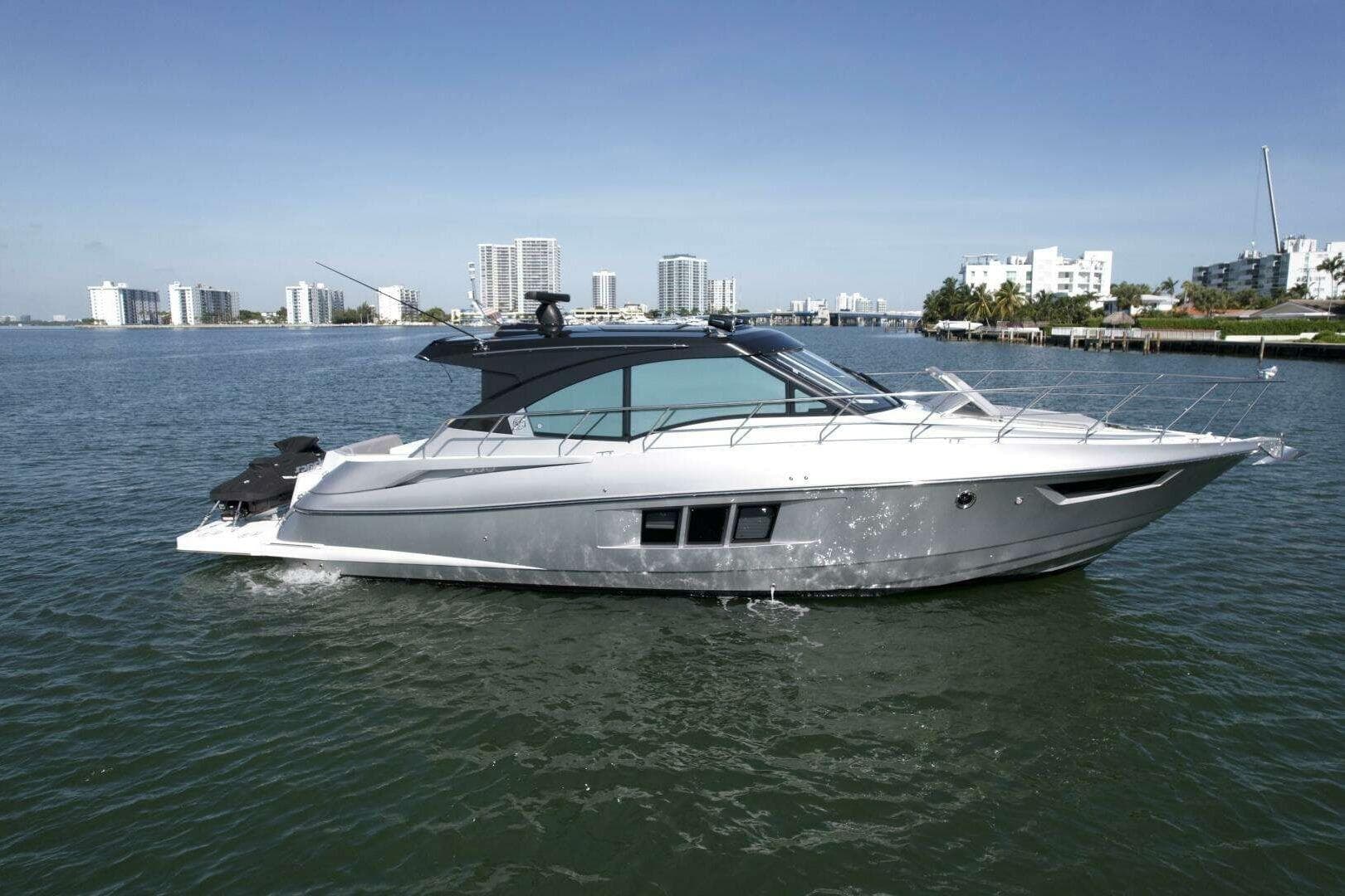 2018 Cruisers Cantius 45 yacht cruising on a sunny day near city skyline.