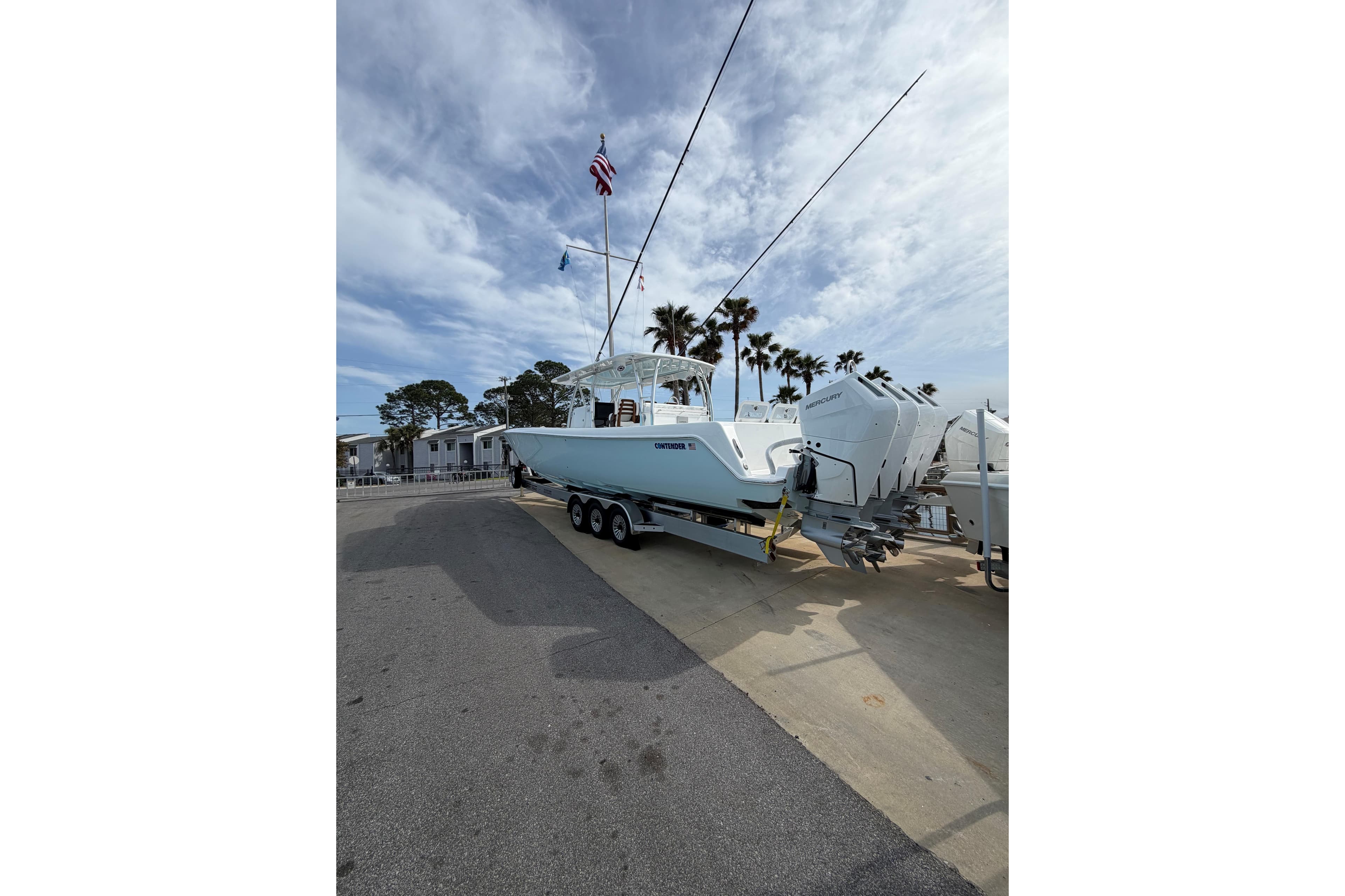 2026 Contender 44 CB boat on trailer with outboard motors, parked near palm trees.