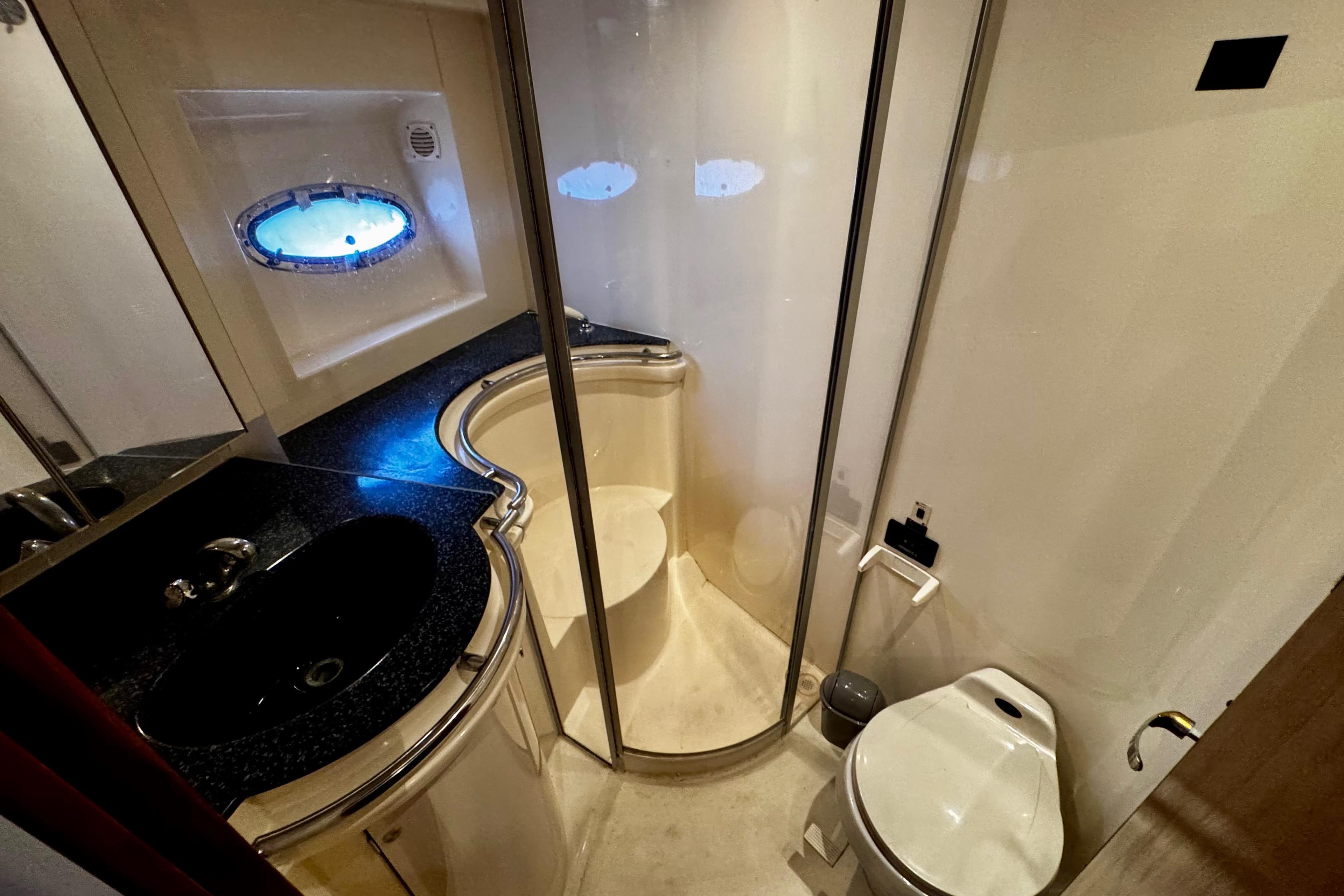 Luxurious bathroom in 2000 Trojan 440 Express yacht with shower, sink, and toilet.